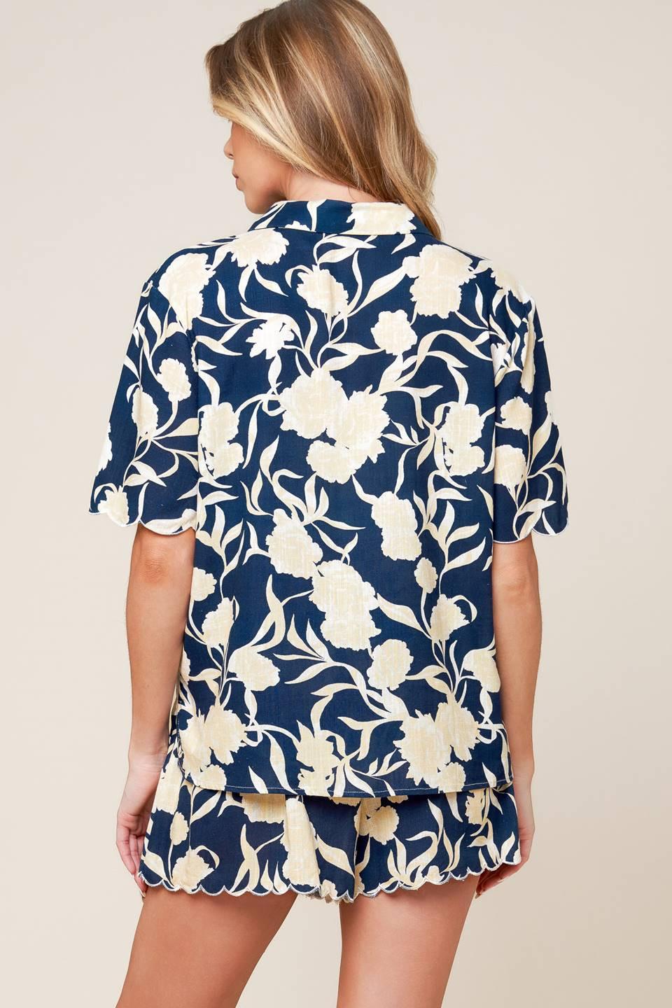 A printed woven top and shorts set. Top featuring collar, button down and short sleeve. Shorts with elasticized back waistband