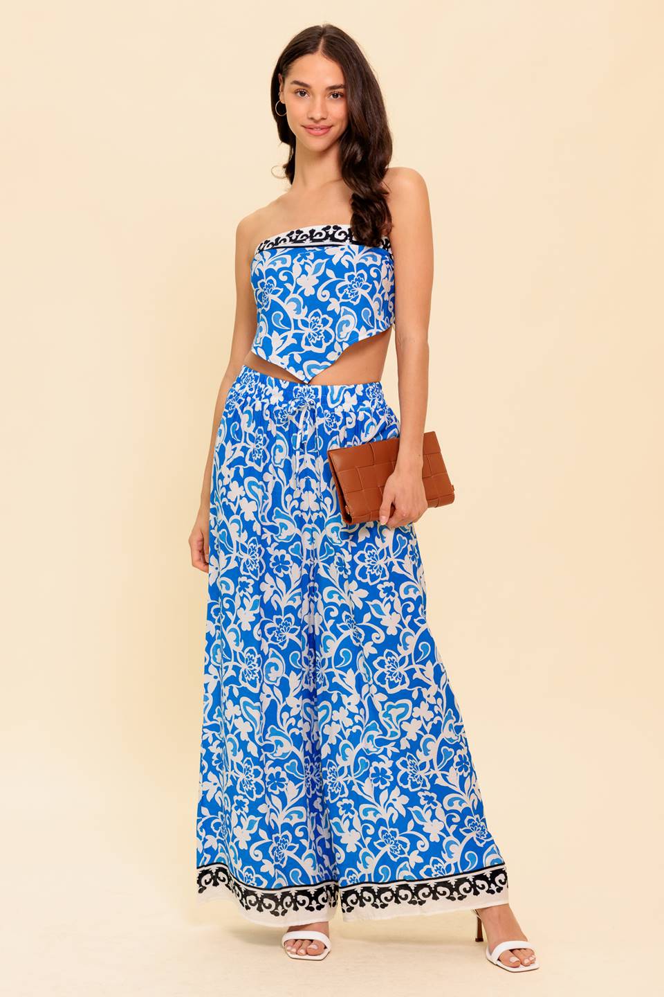 A printed woven top and pant set. Top featuring strapless with back tie. Bottom featuring elasticized waistband with front tie and wide leg