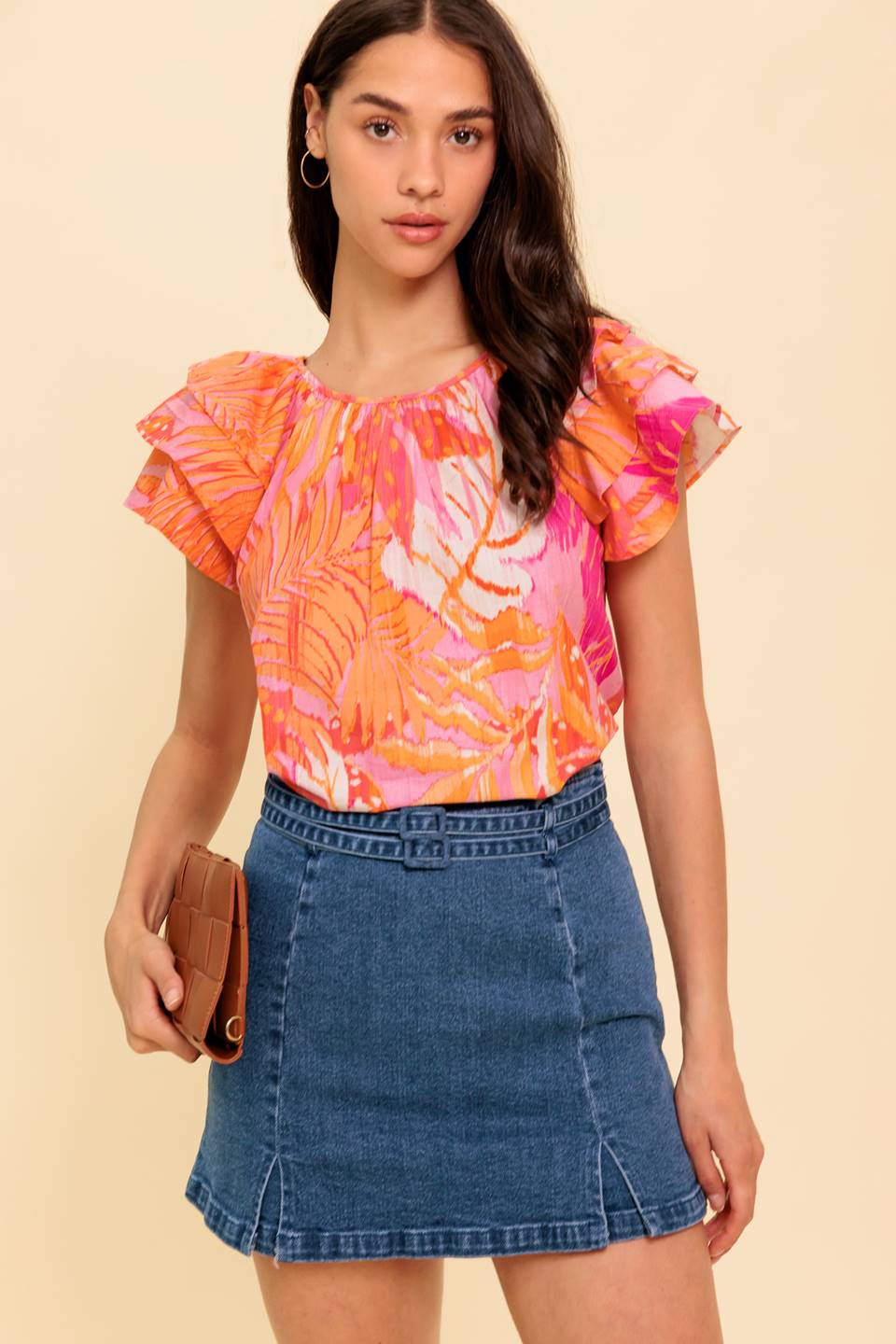 A printed woven top featuring round neckline, layered flutter sleeve and back neck button closure