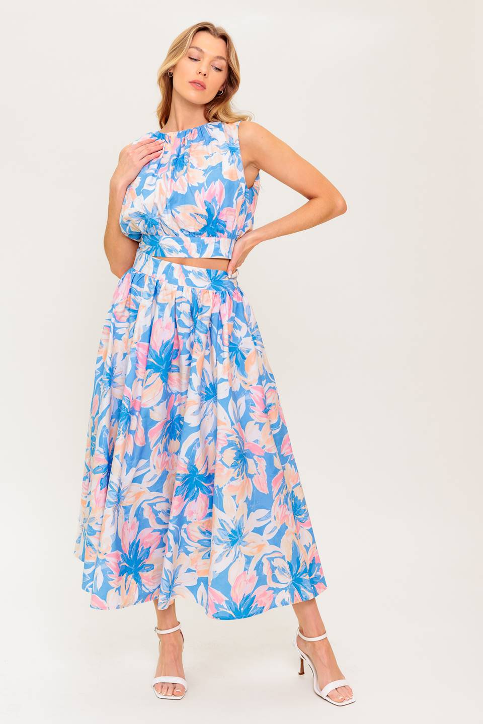 A printed woven top and skirt set. Top featuring side neckline, shirring, sleeveless and back tie and button closure. Full skirt with side zipper closure