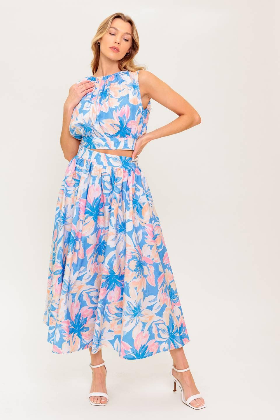 A printed woven top and skirt set. Top featuring side neckline, shirring, sleeveless and back tie and button closure. Full skirt with side zipper closure