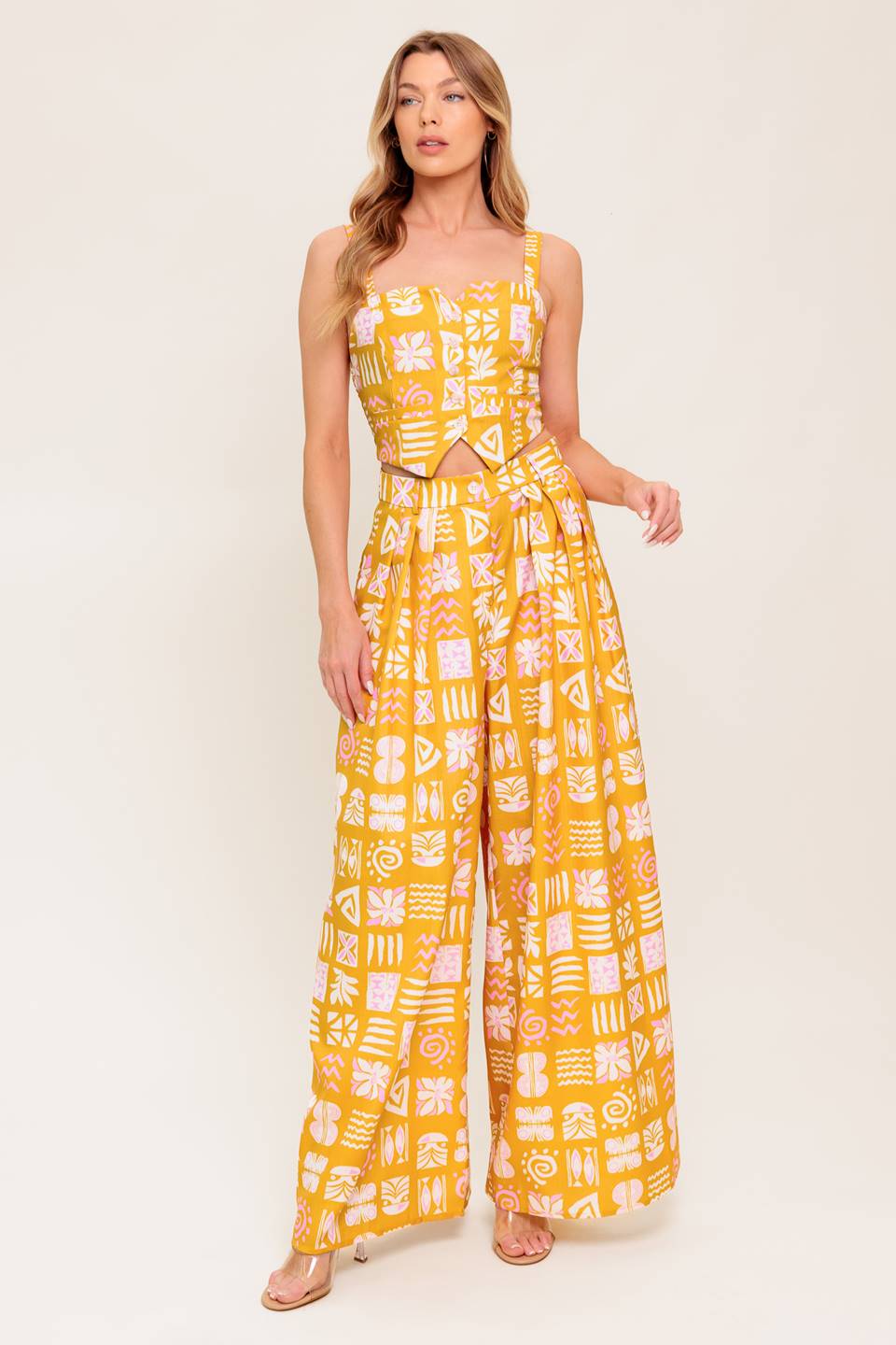 A printed woven top and pant set. Top featuring front button down with smocked back bodice. Pant featuring front closure and wide leg.