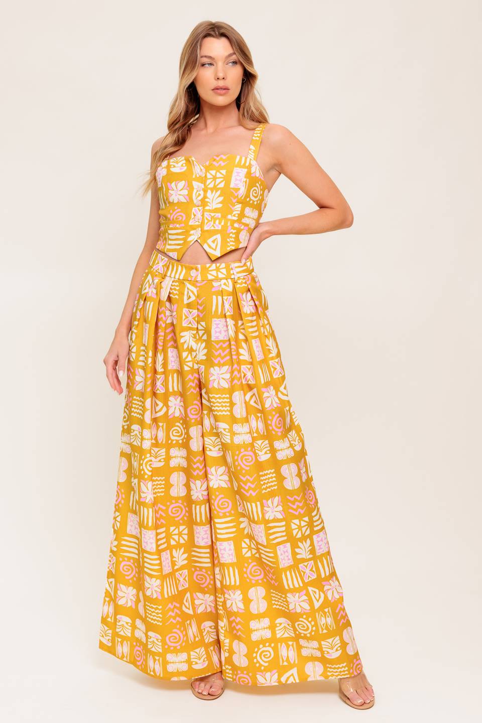 A printed woven top and pant set. Top featuring front button down with smocked back bodice. Pant featuring front closure and wide leg.