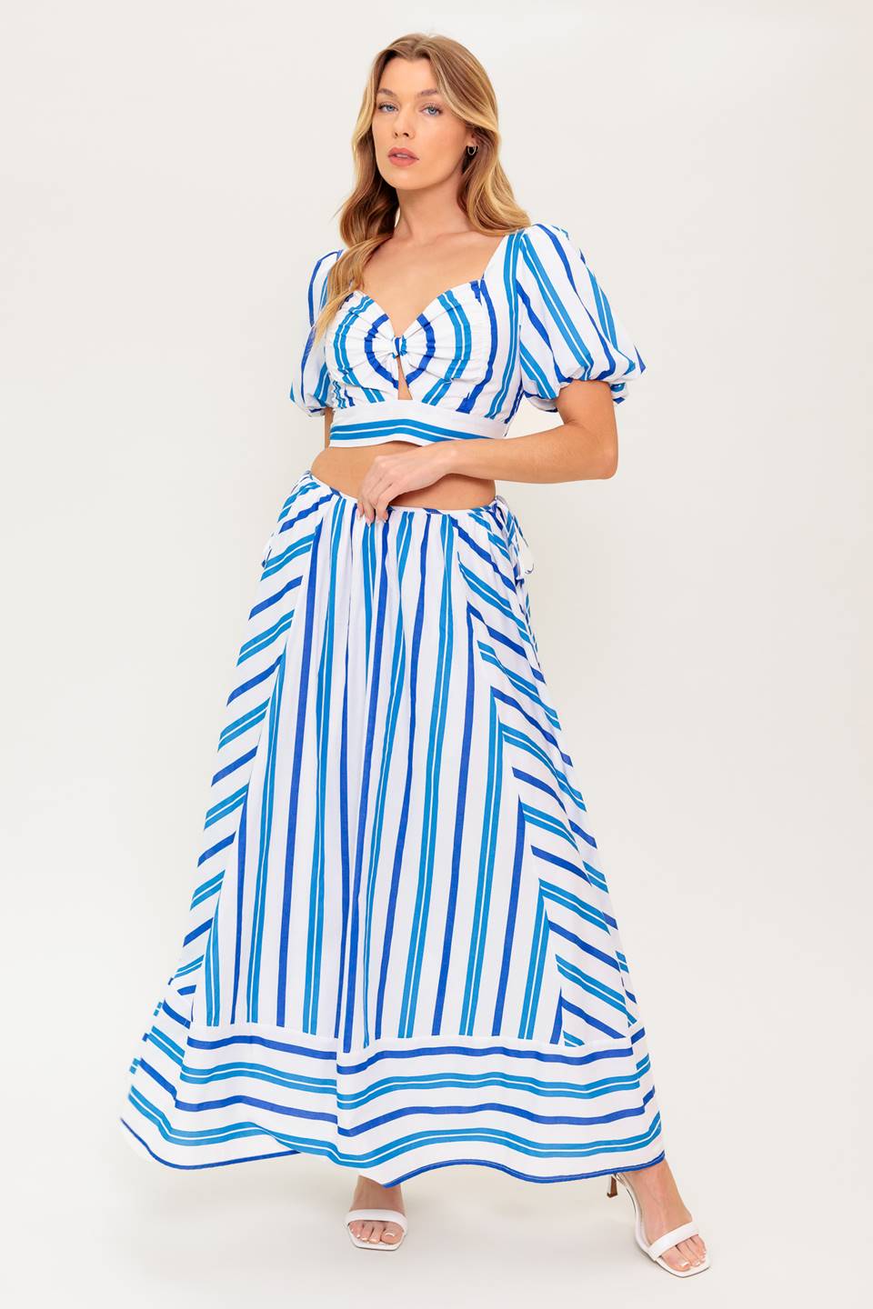 A striped woven top and skirt set. Top featuring sweetheart neckline with center bow and cut out, short puff sleeve and smocked back bodice. Circle skirt featuring side tie and zipper closure