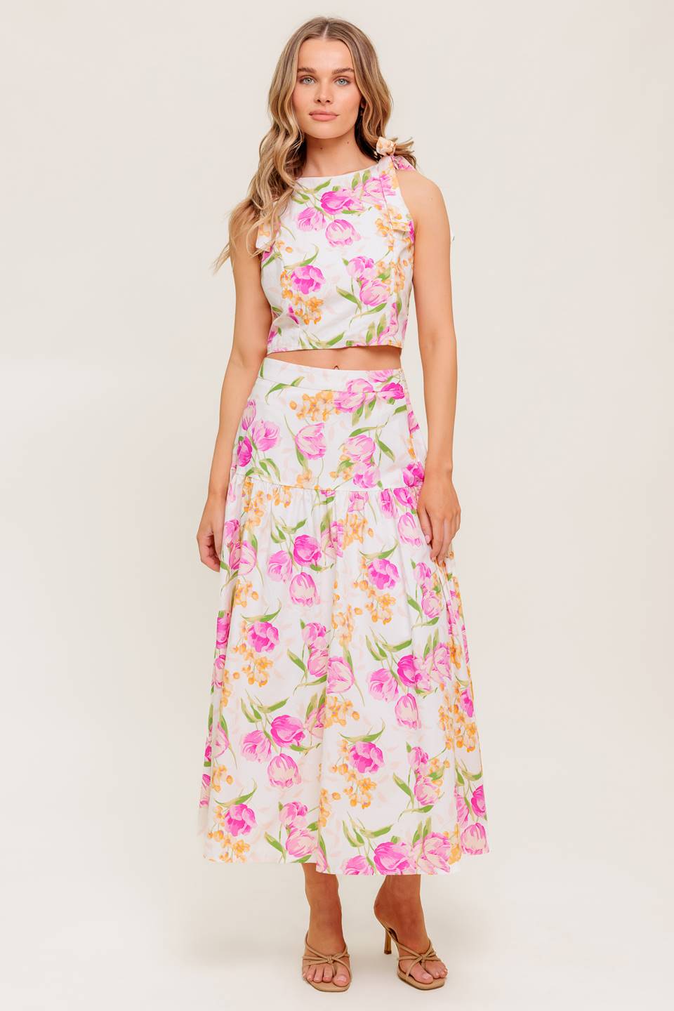 A printed woven top and skirt set. Top featuring crop length, round neckline, sleeveless, shoulder tie and back zipper closure. Midi skirt with side zipper closure.