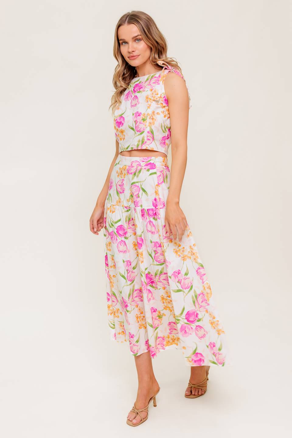 A printed woven top and skirt set. Top featuring crop length, round neckline, sleeveless, shoulder tie and back zipper closure. Midi skirt with side zipper closure.