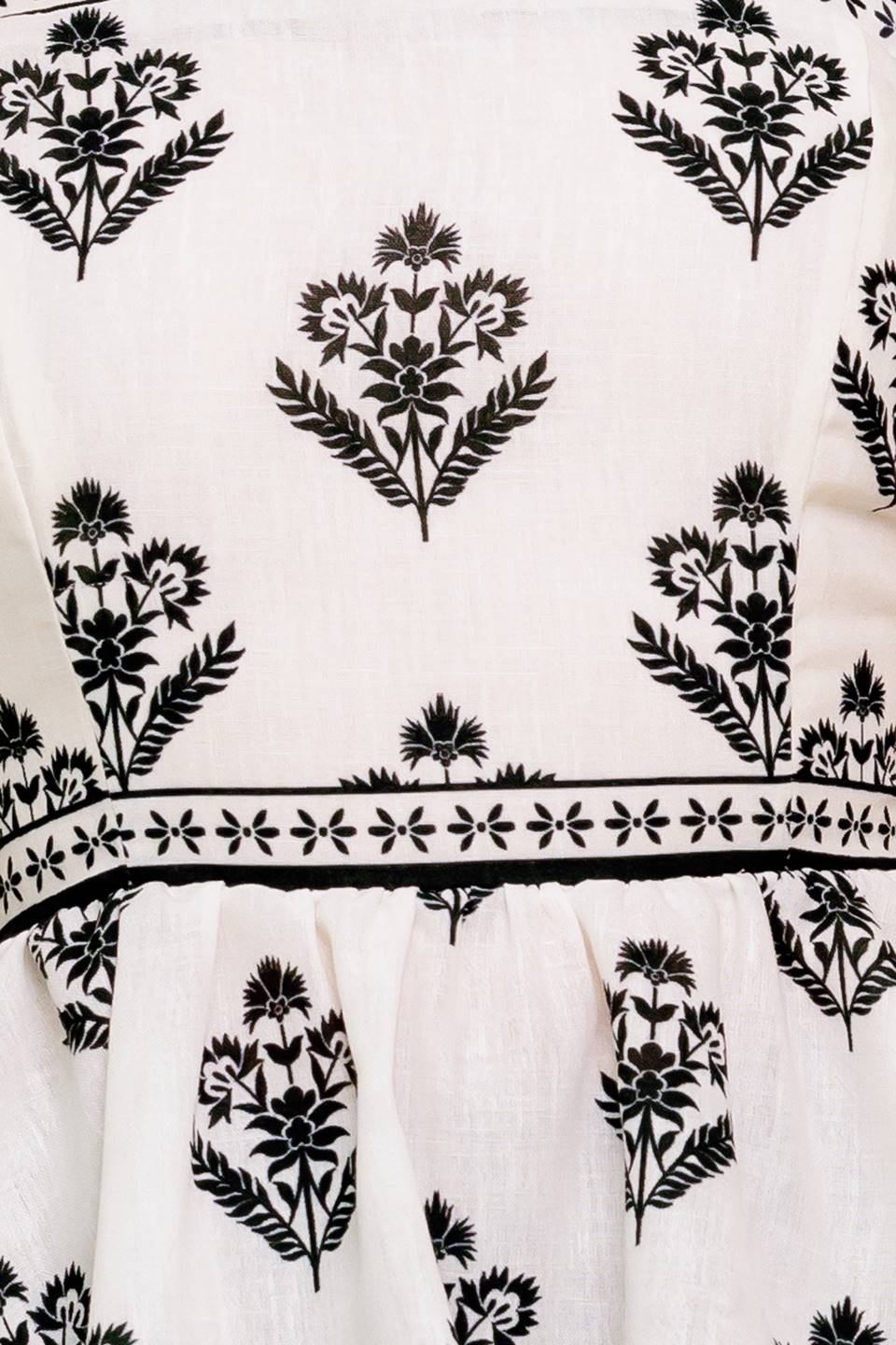 A printed woven top featuring straight neckline, shoulder tie, peplum and back zipper closure.