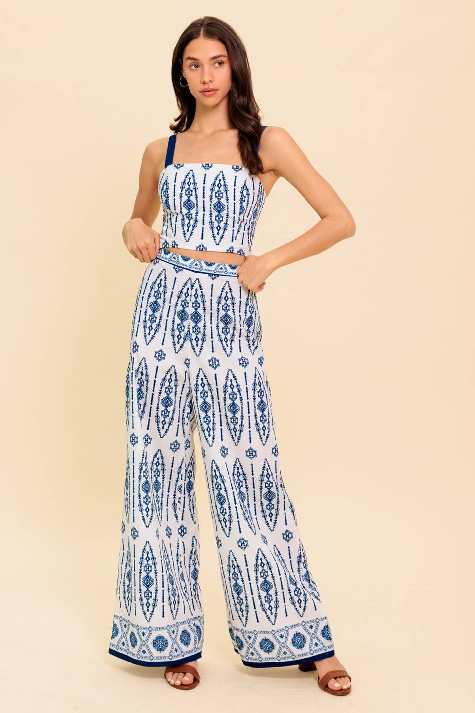 A printed woven top and pant set. Crop top featuring straight neckline, straps and smocked back bodice. Pant featuring wide leg and side zipper closure