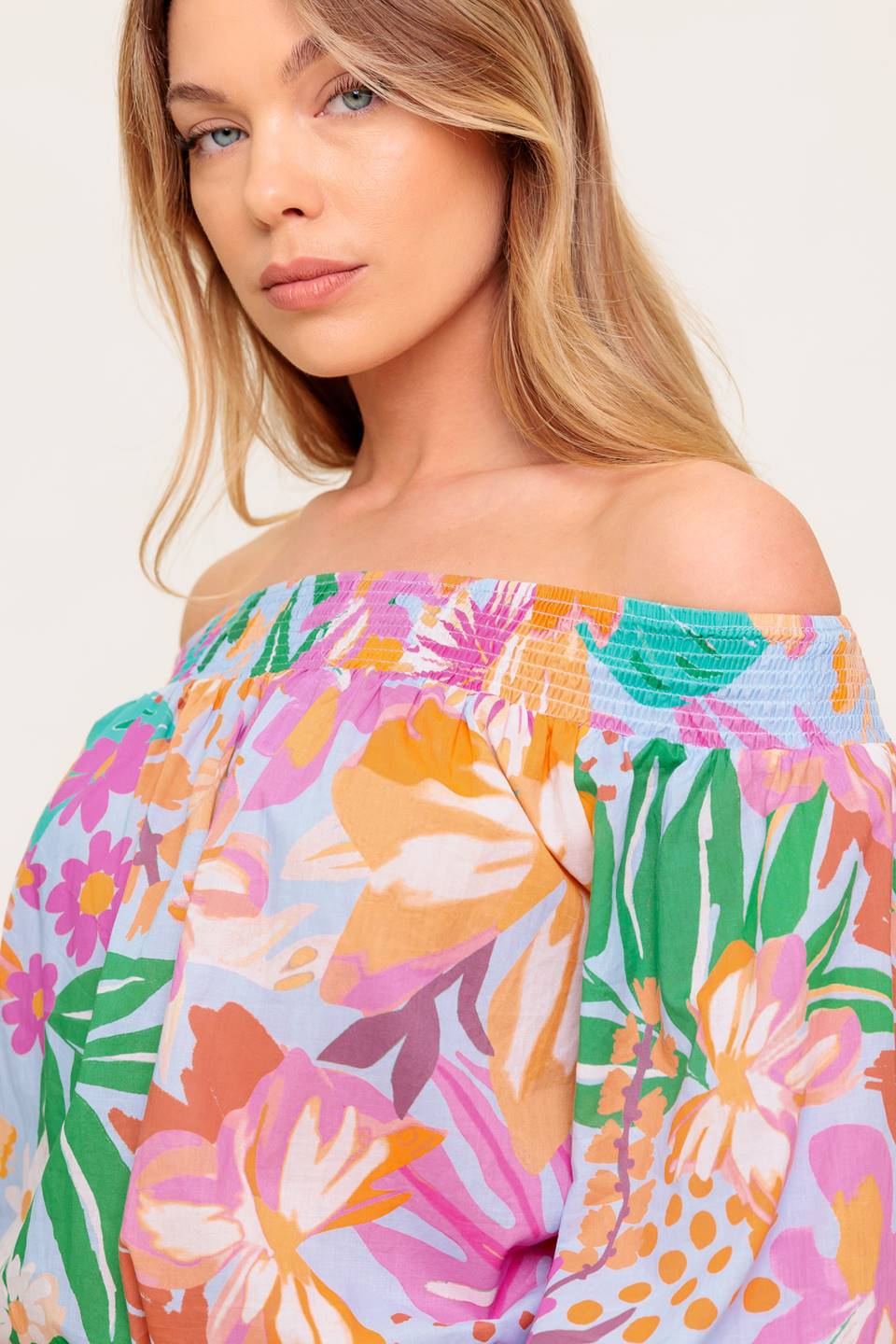 A printed woven top with off shoulder neckline.