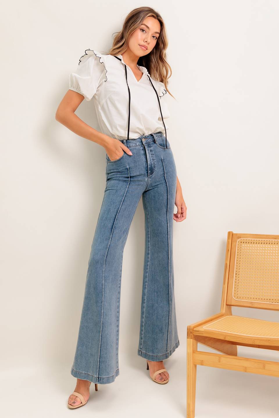 A solid woven top featuring ruffed neckline with tie, scallop edge shoulder and short sleeve