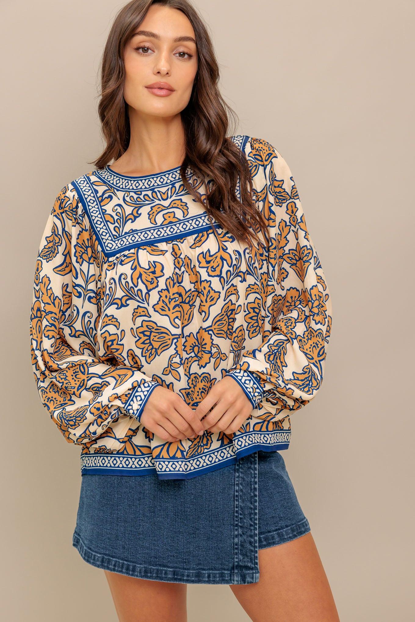 A printed woven top featuring round neckline, yoke, long sleeve and back neck button closure