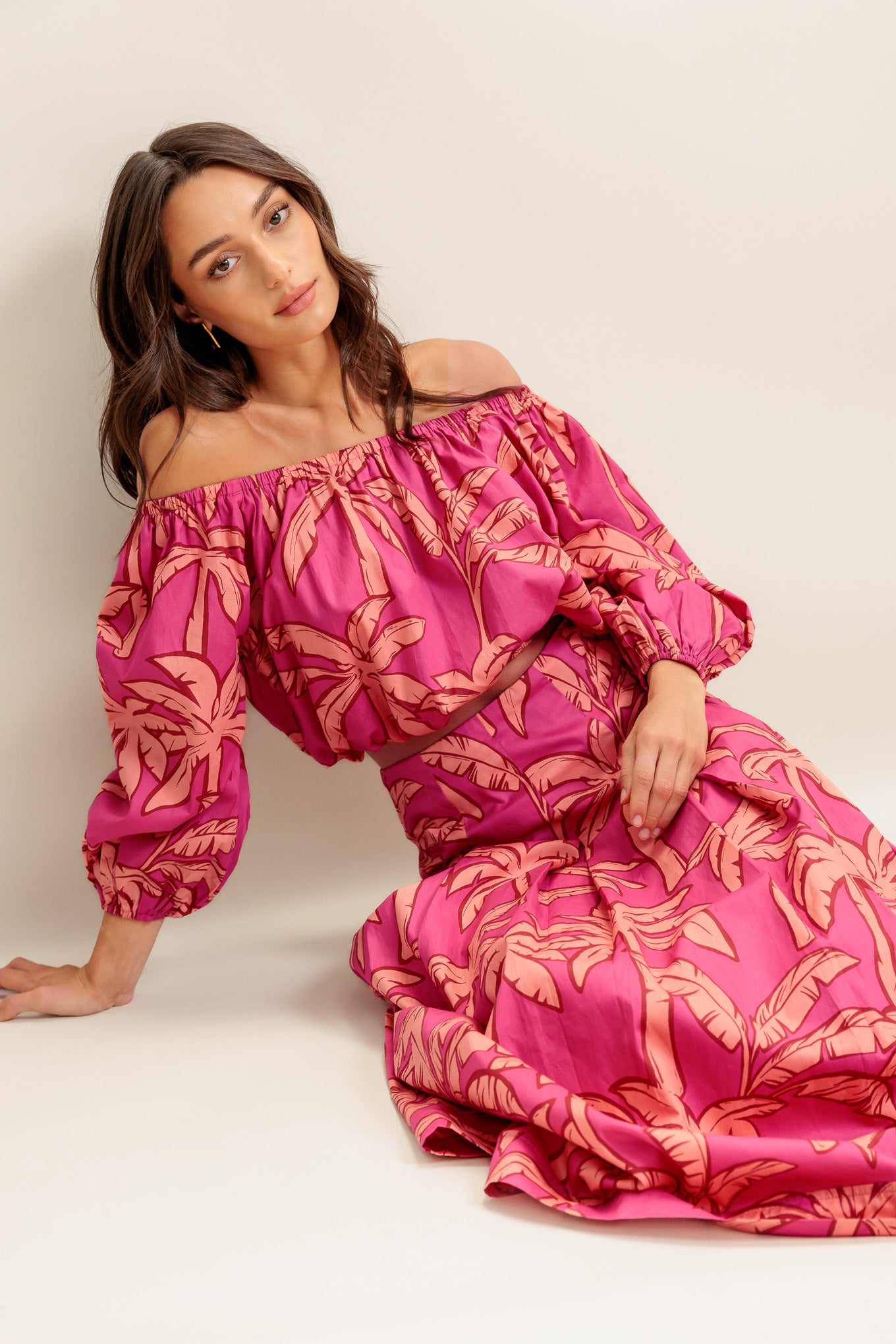 A printed woven top and skirt set. Top featuring off shoulder neckline, 3/4 sleeve and elasticized waist. Circle midi skirt with back zipper closure