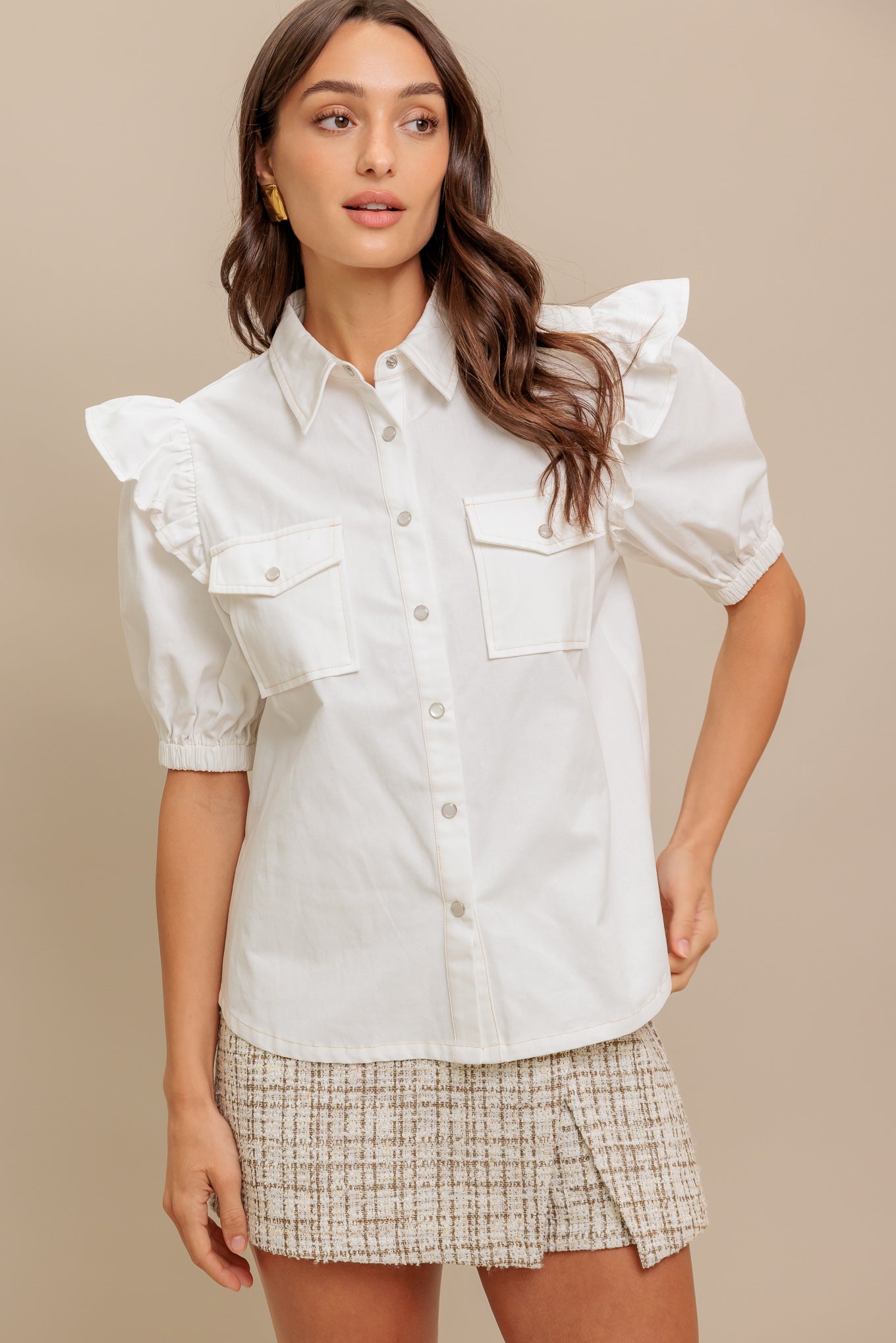 A solid white woven top featuring collar, snap button down, ruffled shoulder, short puff sleeve and pockets