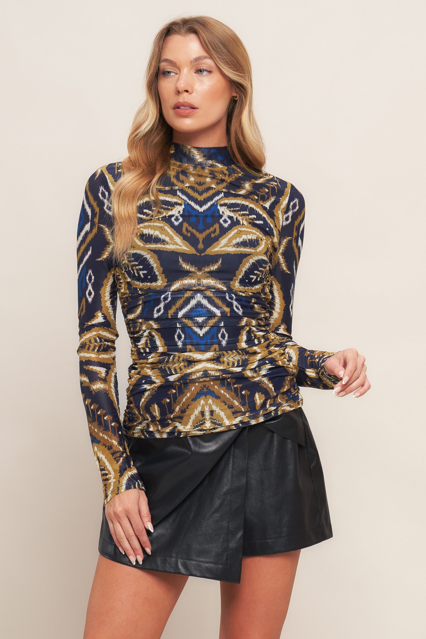 A printed power mesh top with high neckline and long sleeve with side shirring.