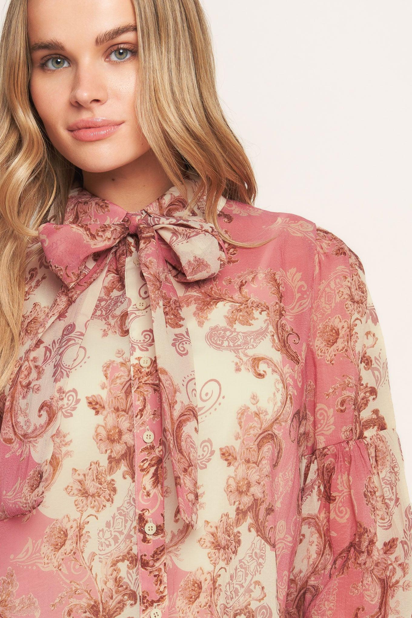 A printed woven top featuring collar, button down, neck tie and long lantern sleeve