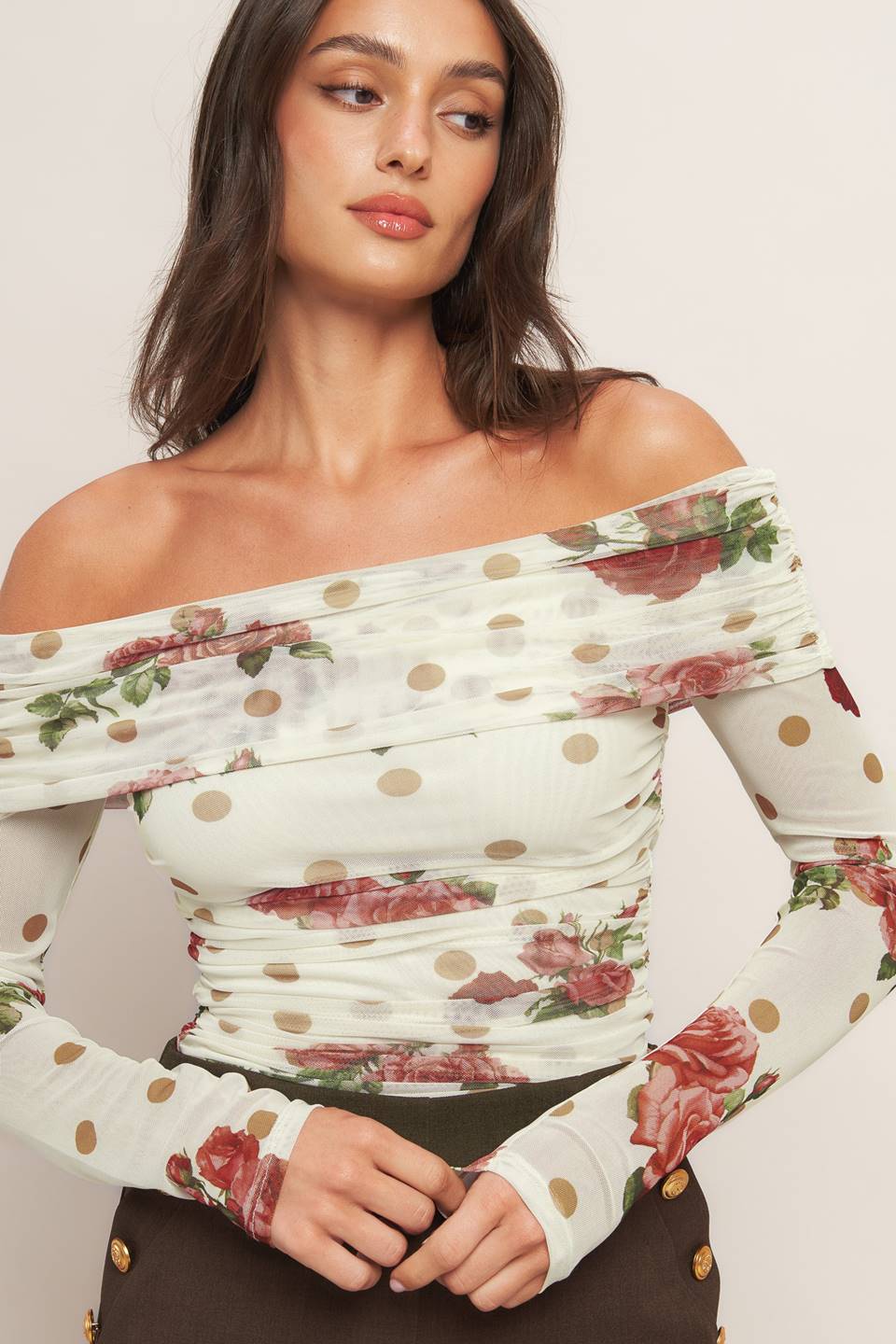 A printed power mesh top featuring off shoulder neckline with fold over, long sleeve and shirred body