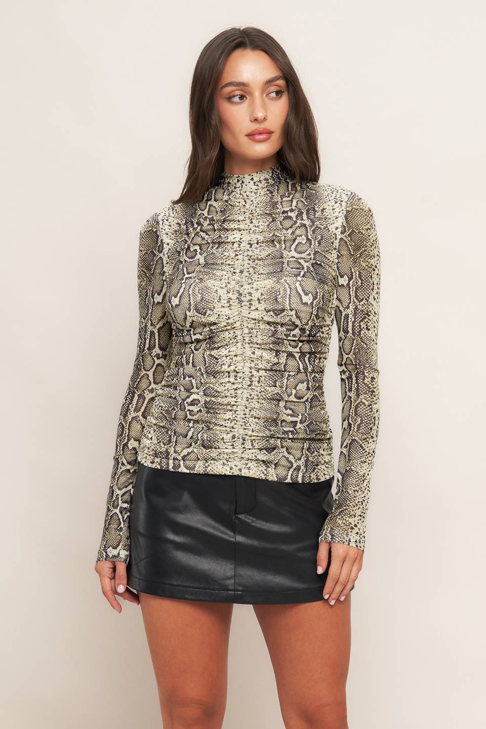 A printed knit top featuring high neckline, shirred front center and back neck button closure