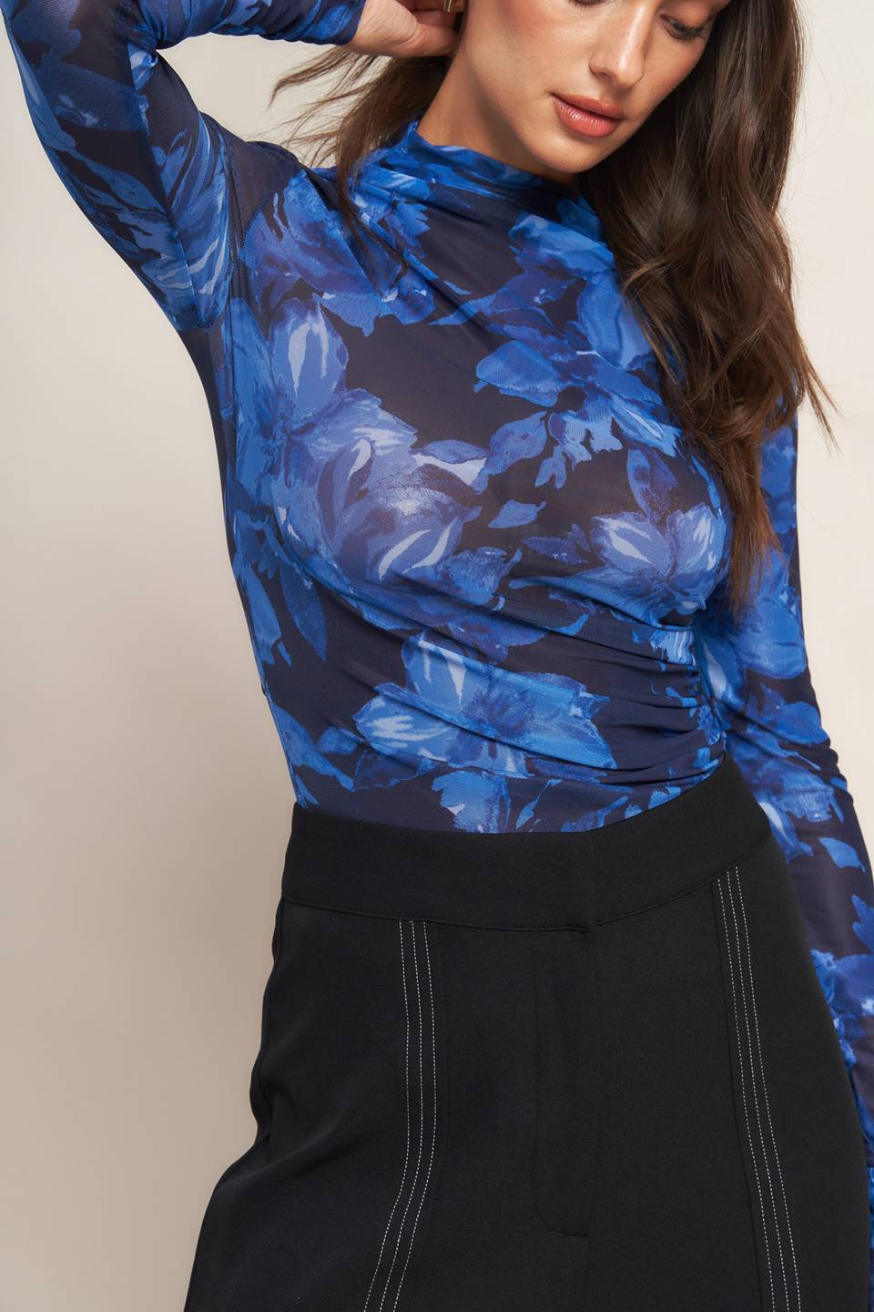 A printed power mesh top featuring high neckline, long sleeve and side shirring