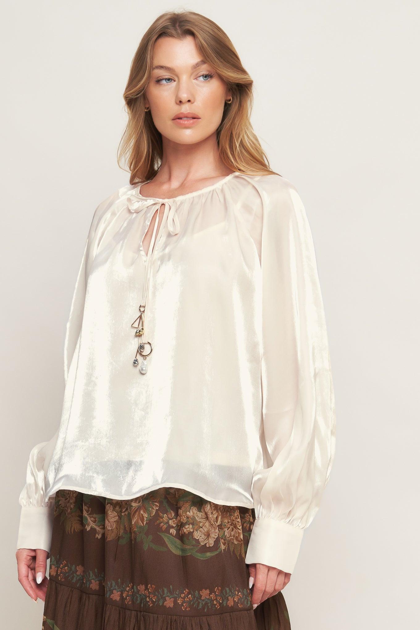 A solid sheen woven peasant top with front tie with embellishment, long sleeve with cuff and cami