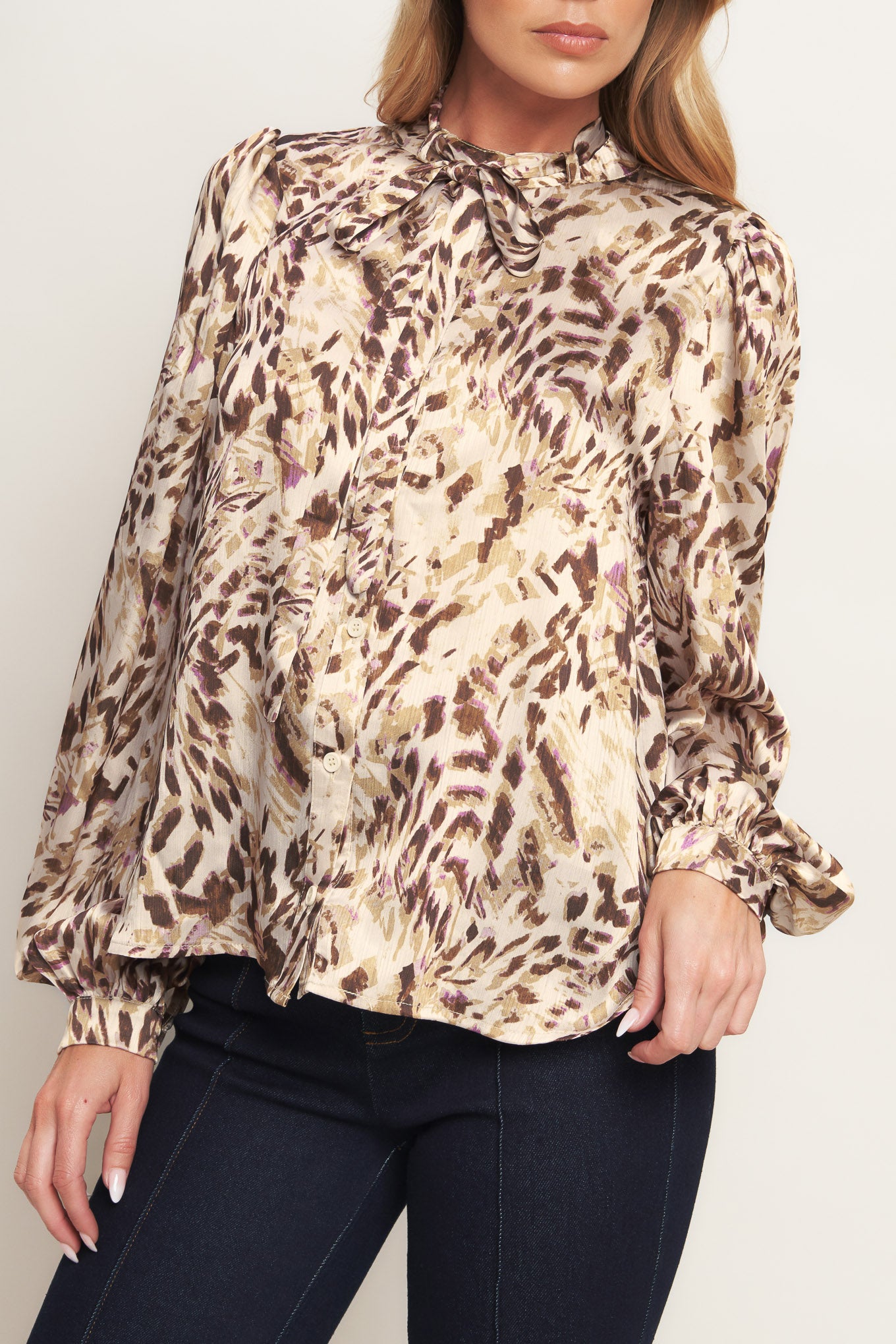 A printed woven top featuring round neckline with skinny tie, button down and long blouson sleeve