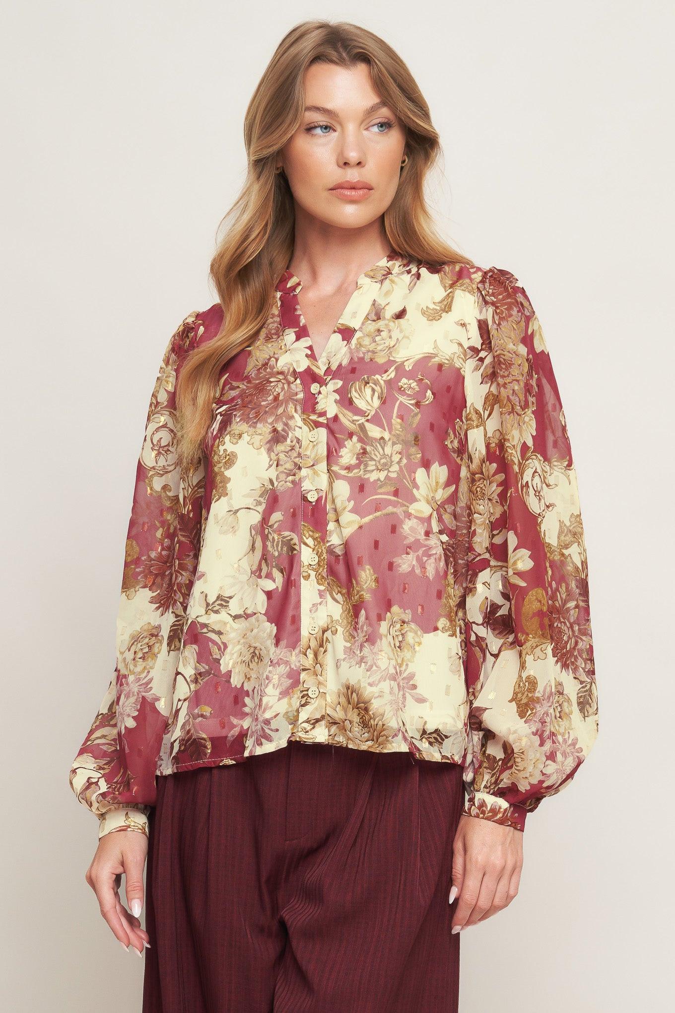 A printed woven top featuring round neckline with V front, long sleeve with cuff and button down closure