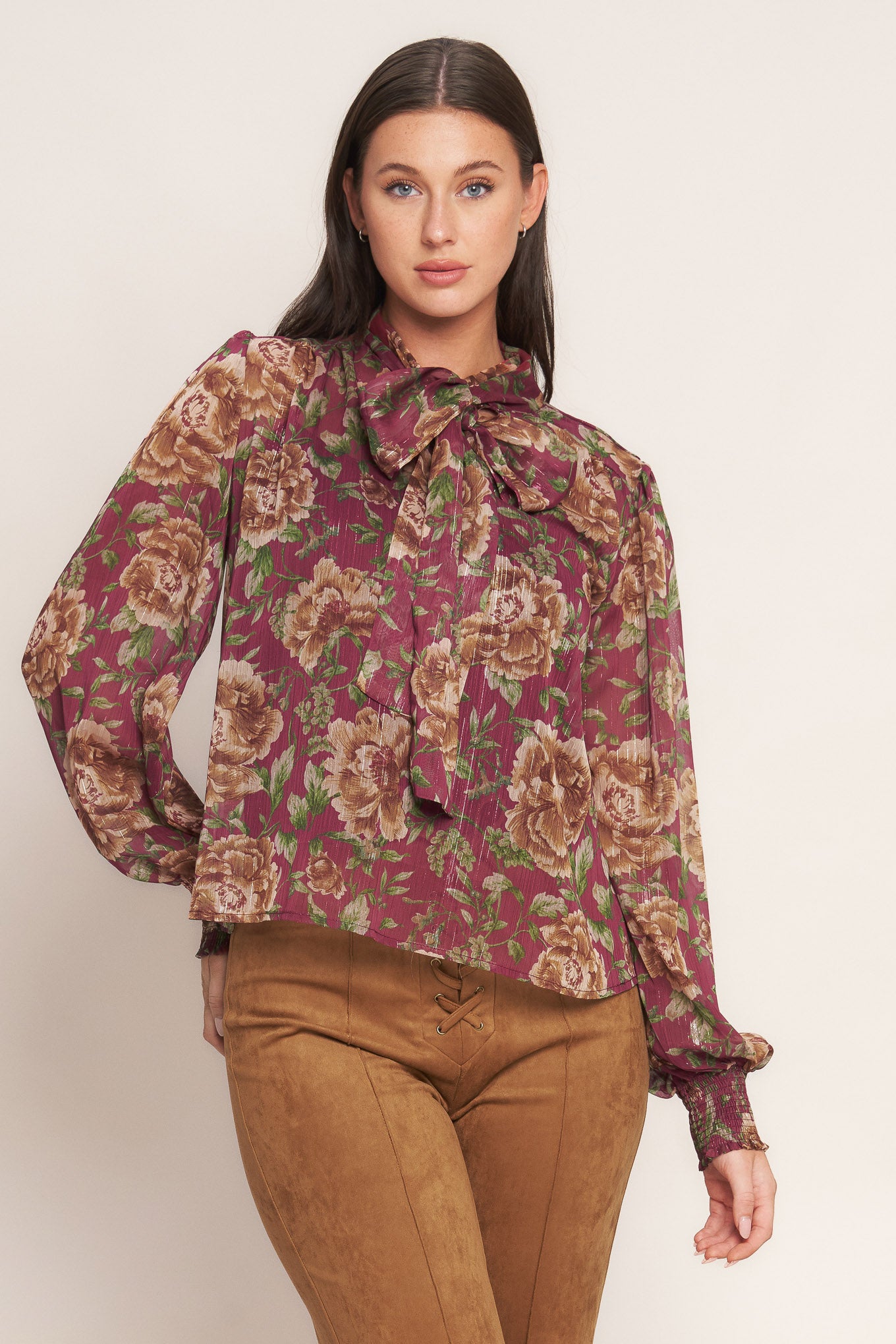 A printed woven top featuring front bow tie and long sleeve with smocked cuff