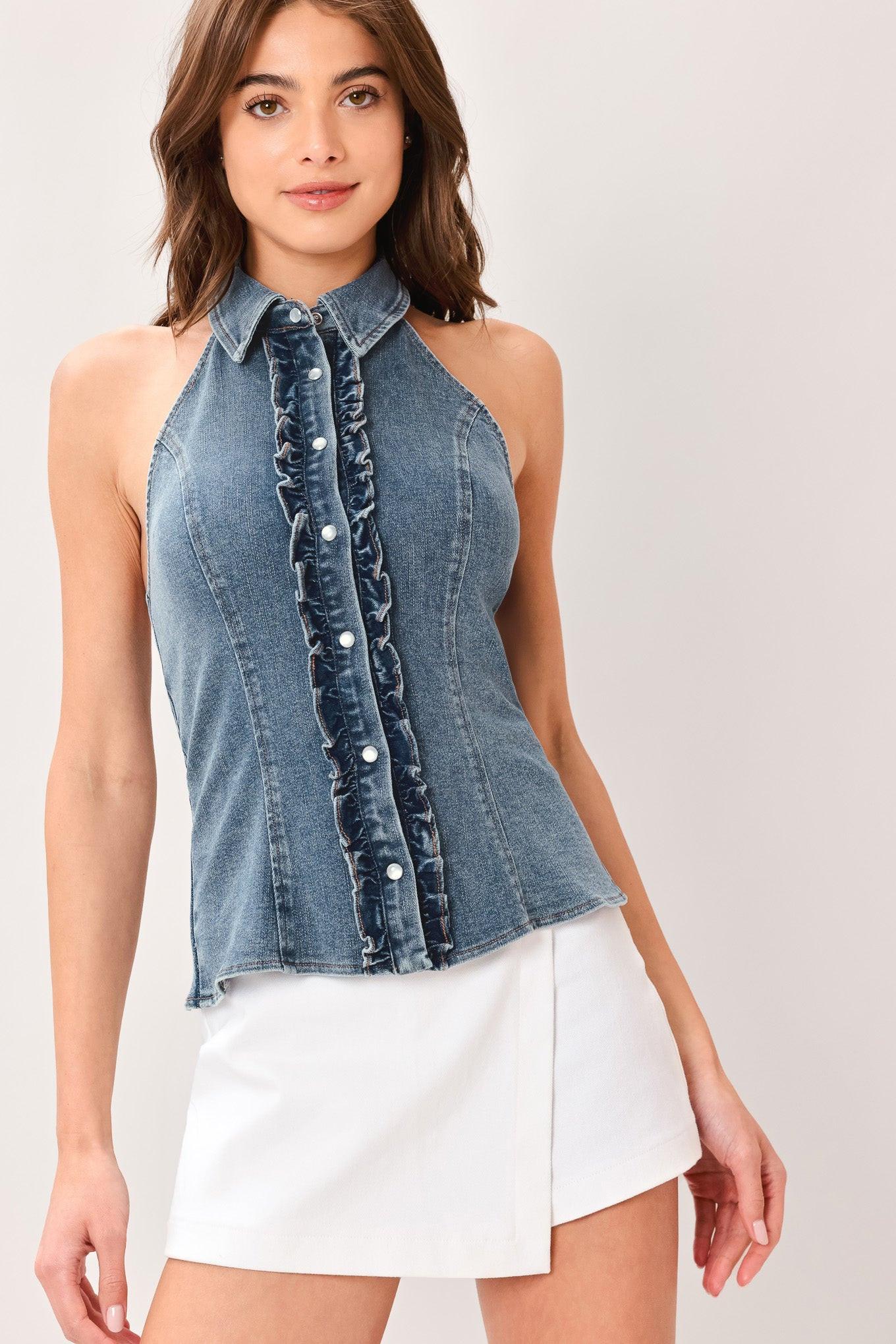 Woman wearing a washed denim top featuring halter neckline with collar, ruffle placket, button down and bare back