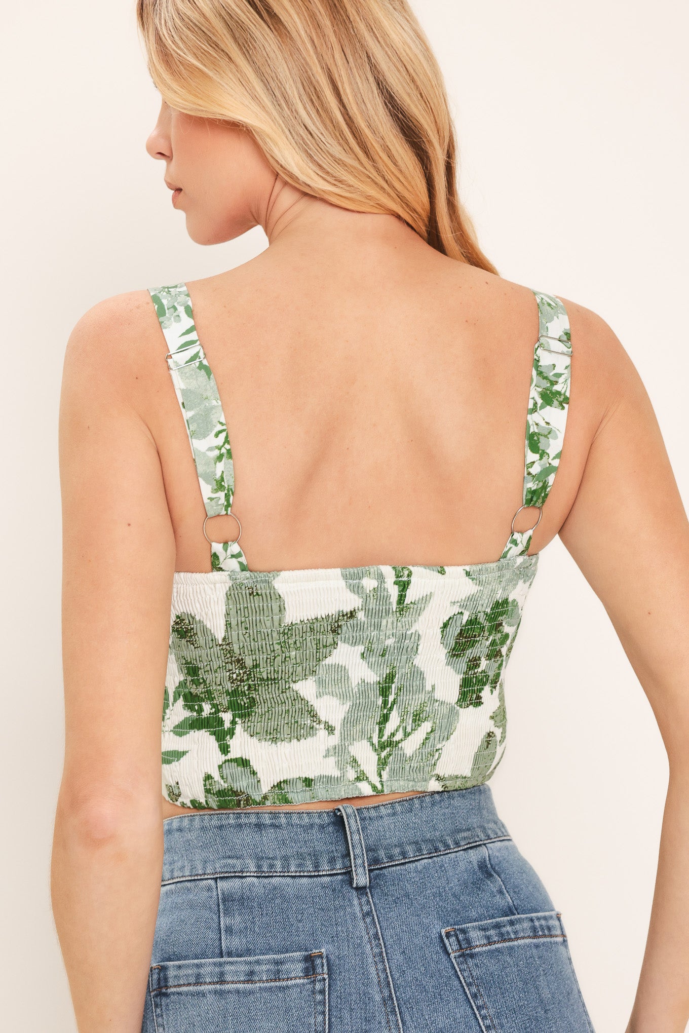 Woman wearing a green floral crop bustier top with smocked back bodice | Flying Tomato