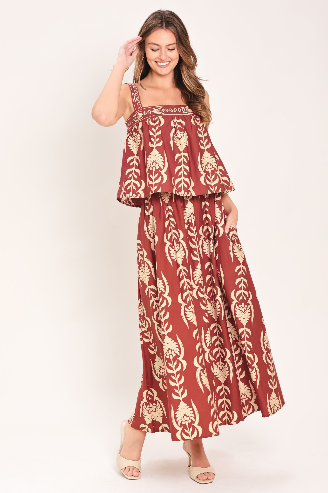 Woman wearing a red and beige patterned top with straight neckline and straps | Flying Tomato