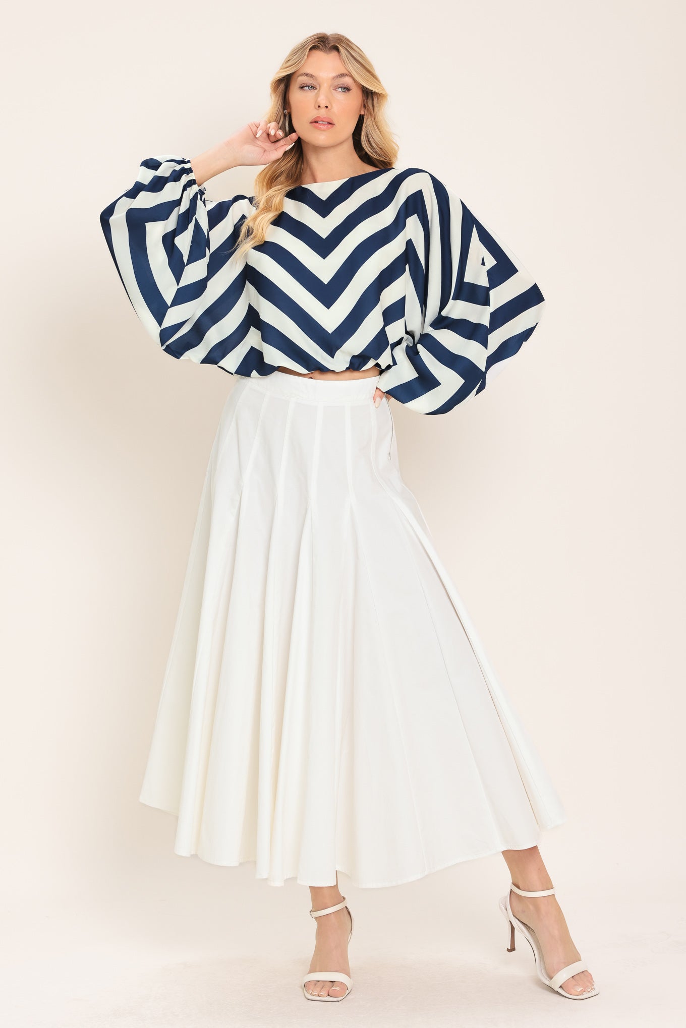 Woman wearing a navy and white chevron patterned top featuring wide neckline, dolman sleeve, elastic waist and back neck button closure | Flying Tomato