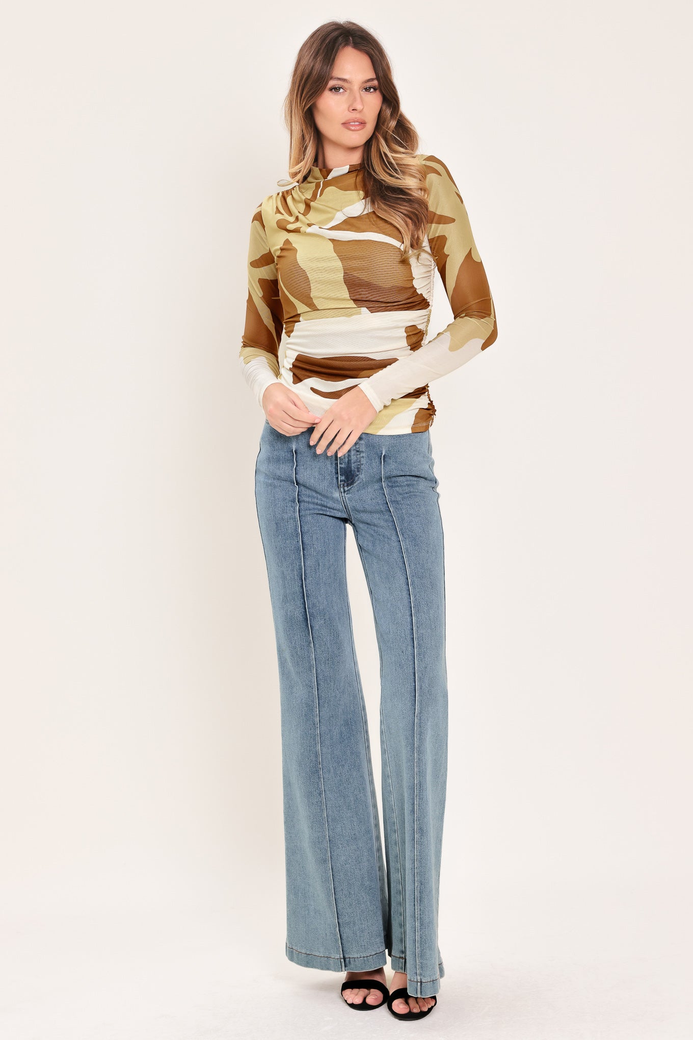Woman wearing a multicolor brown, yellow, and ivory long-sleeve power mesh top with funnel neck and side shirring | Flying Tomato