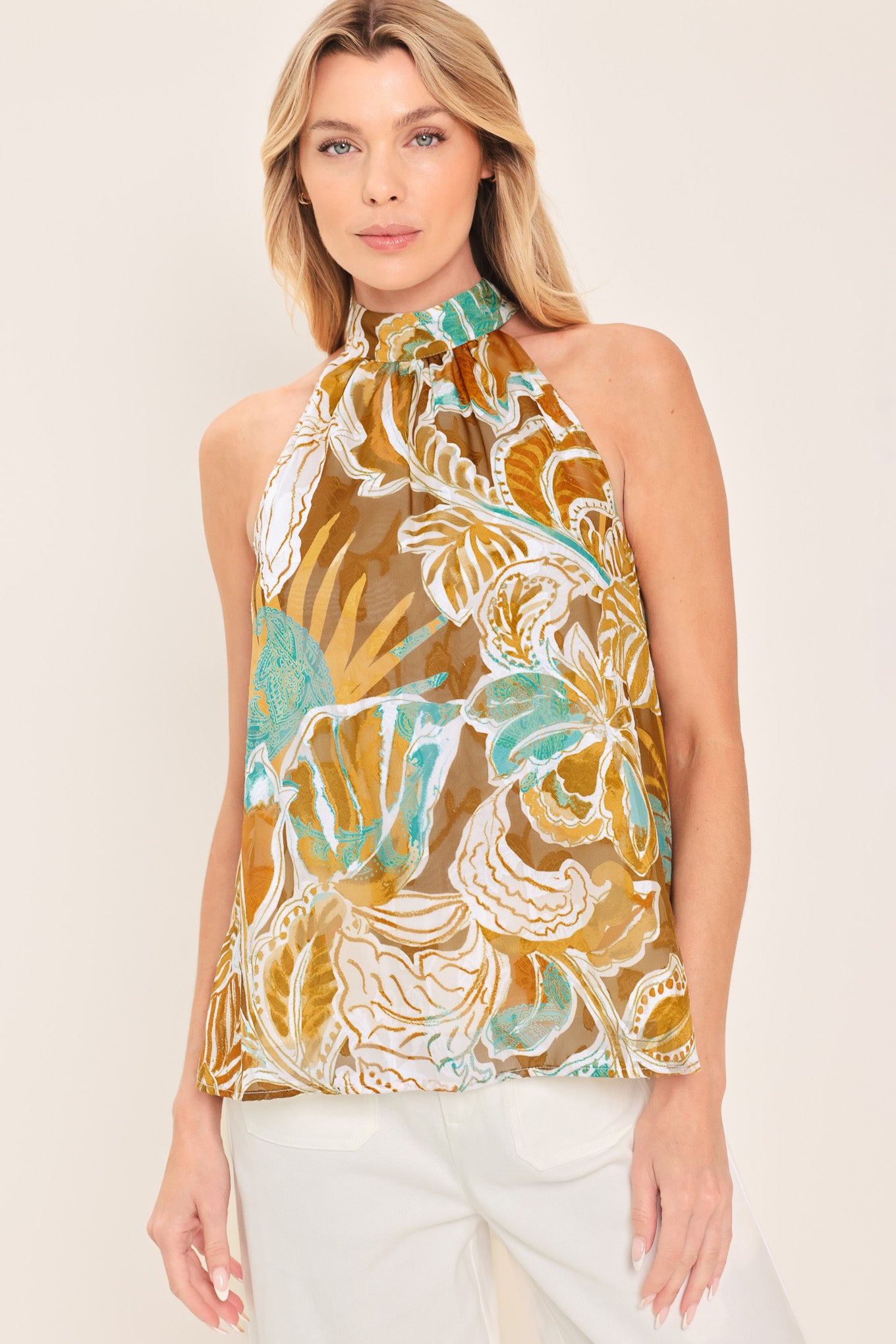 Woman wearing a sleeveless tropical floral jacquard printed top with halter neckline with back neck tie | Flying Tomato