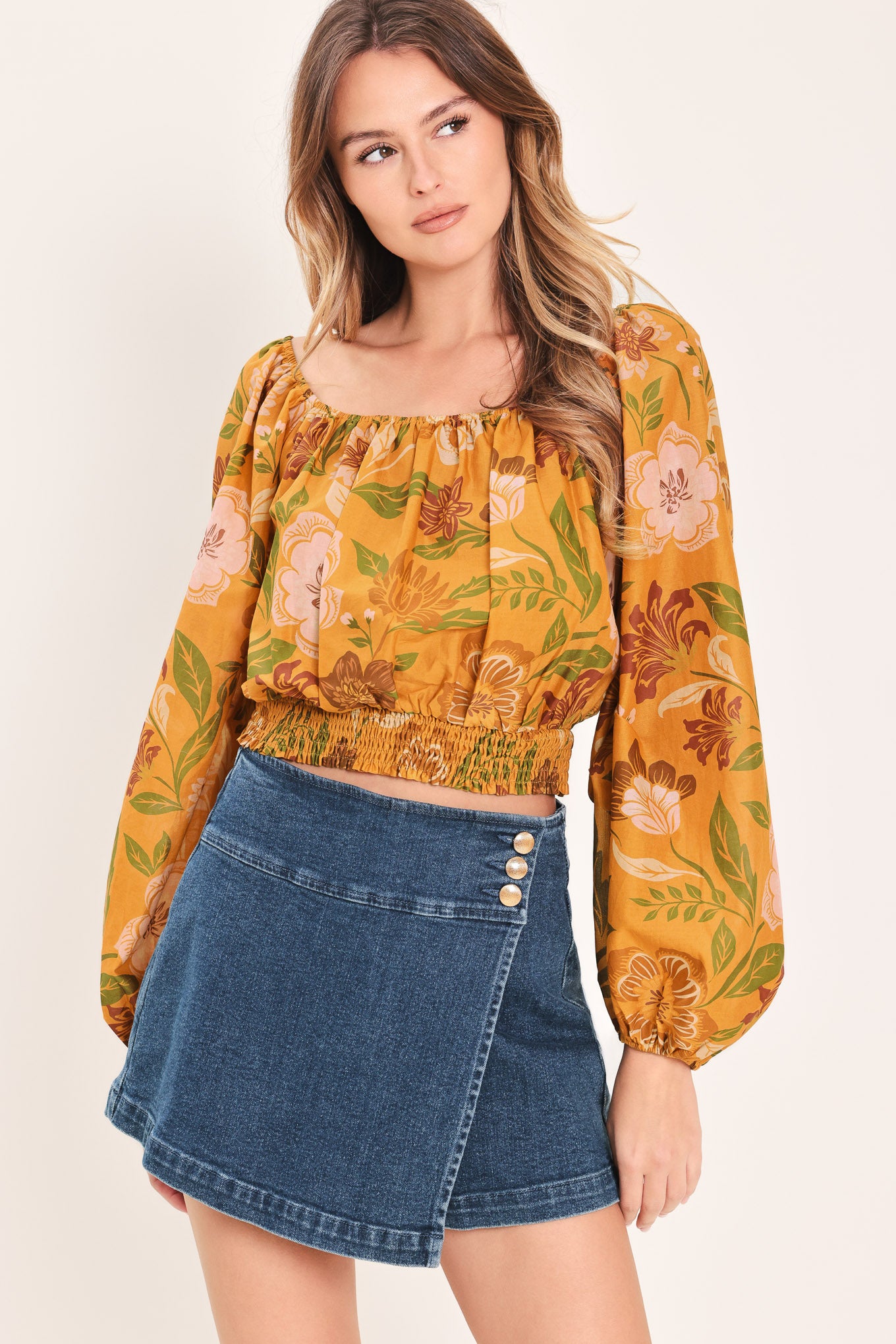 Woman wearing a yellow floral printed blouse featuring square neckline, long sleeve and smocked waistband | Flying Tomato