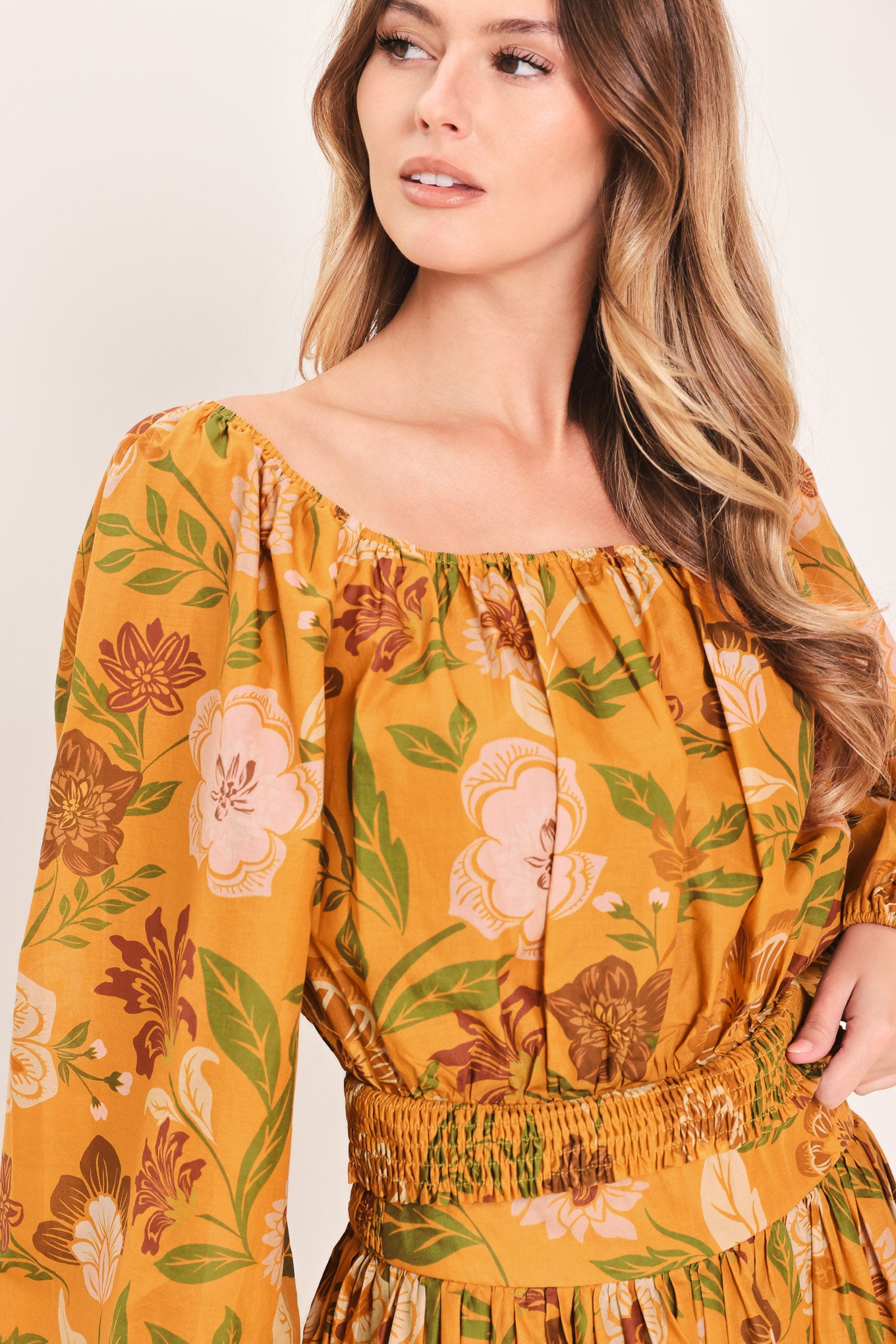 Woman wearing a yellow floral printed blouse featuring square neckline, long sleeve and smocked waistband | Flying Tomato