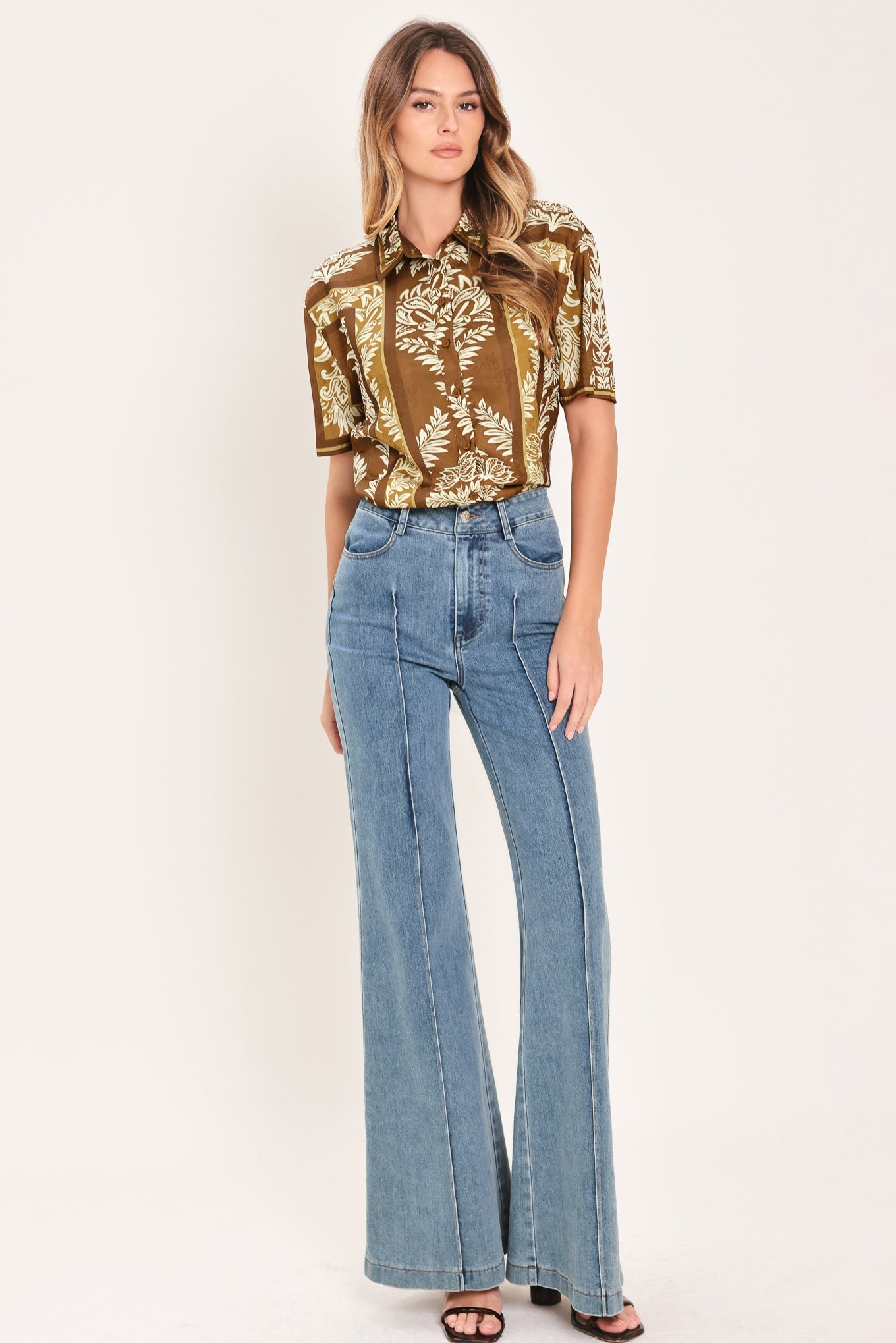 Woman wearing a brown floral patterned button down top | Flying Tomato