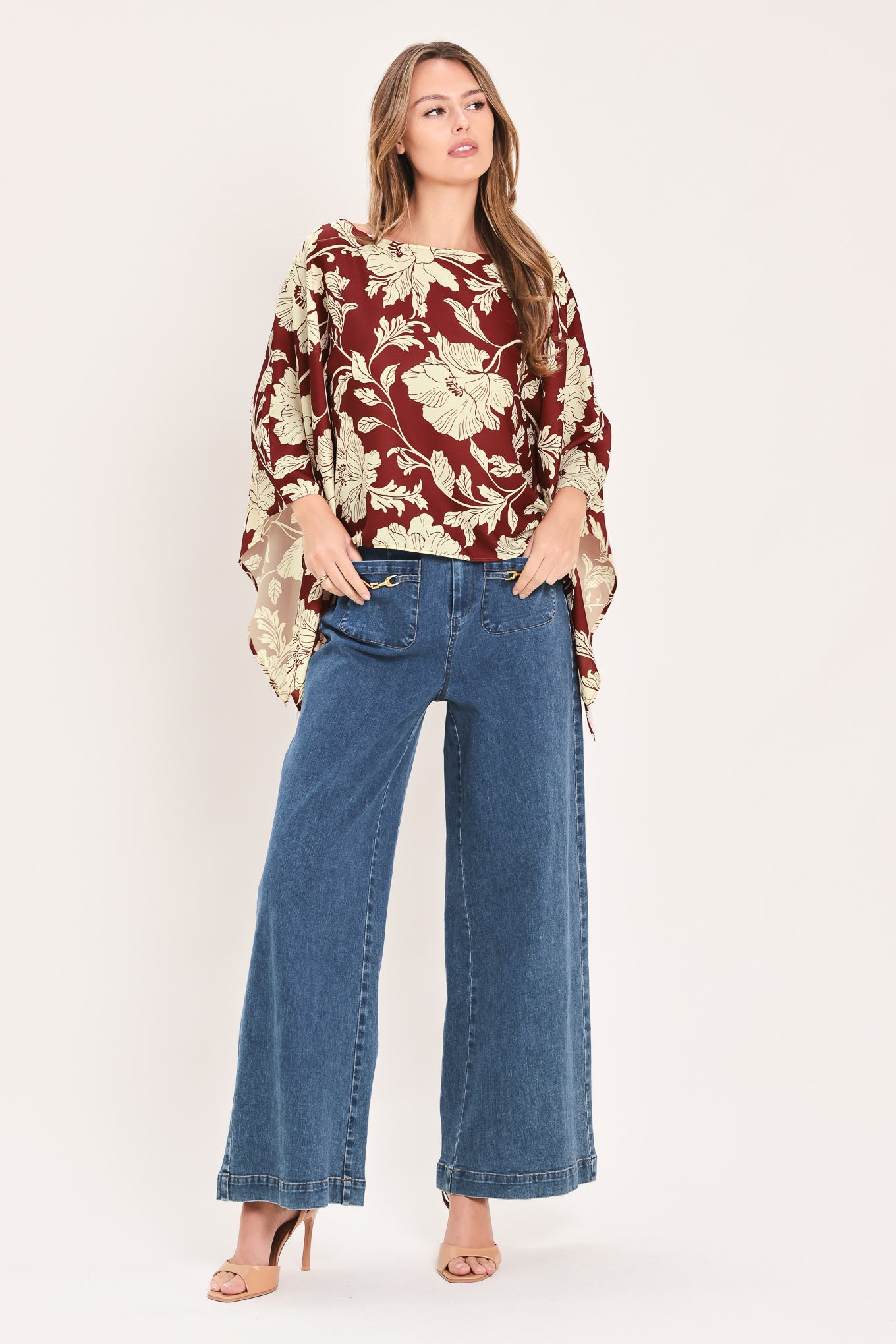 A woman wearing a burgundy and cream floral print top with wide bell sleeves | Flying Tomato