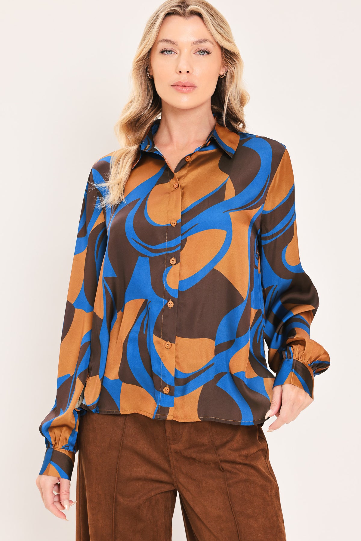 A woman modeling a long-sleeve button-up shirt with an abstract wavy pattern in brown, blue, and black | Flying Tomato