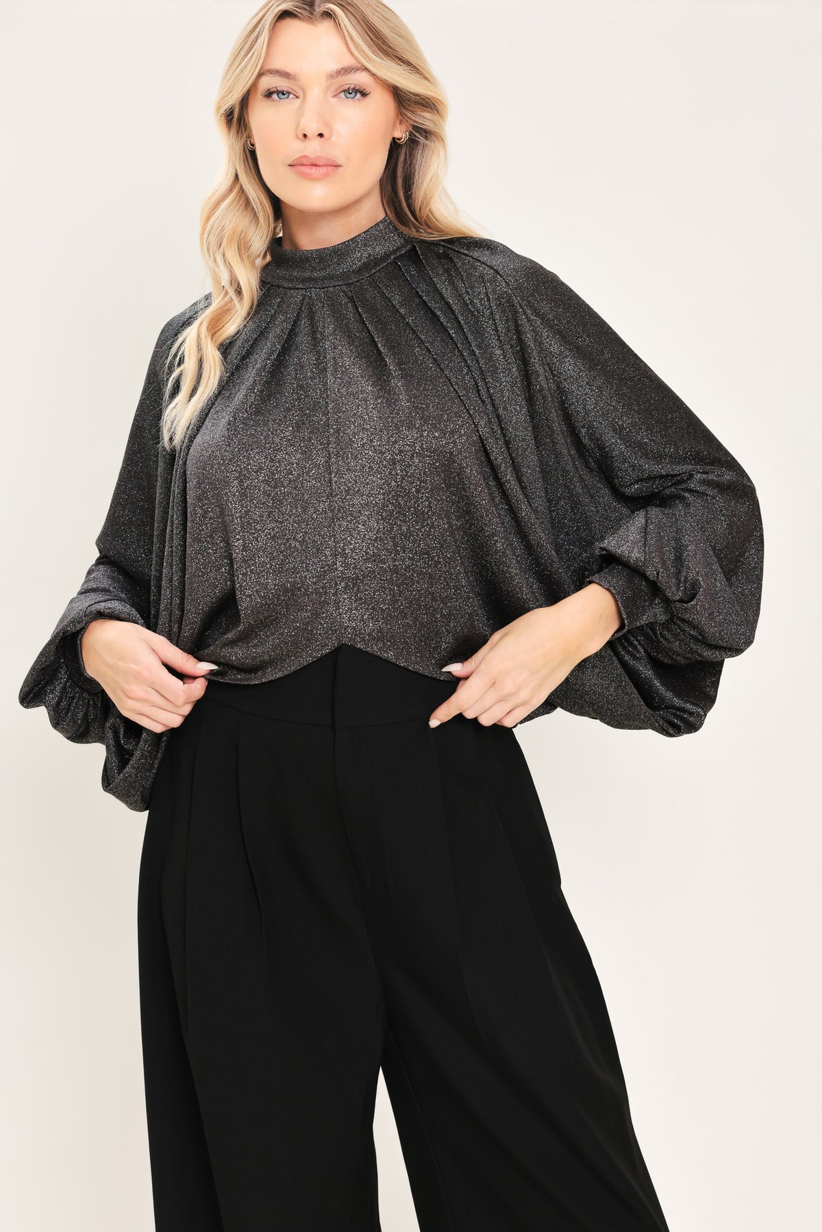 A woman modeling a dark gray metallic high-neck blouse with voluminous balloon sleeves | Flying Tomato