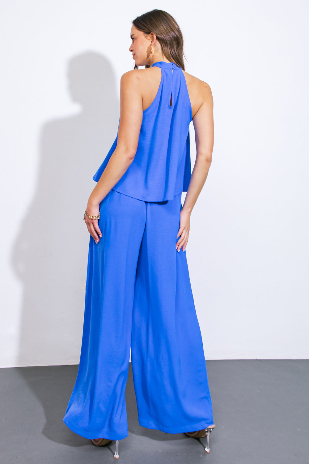 A sophisticated woven top and bottom set, showcasing a halter neckline with a draped front and back button closure, paired with wide leg pants.
Details:
Self : 100% Polyester
Size & Fit
- Model is 5`9" And Wearing Size Small
- Measurements Taken From Size Small
- Approx. Length: Top- 22" Bottom- 44"