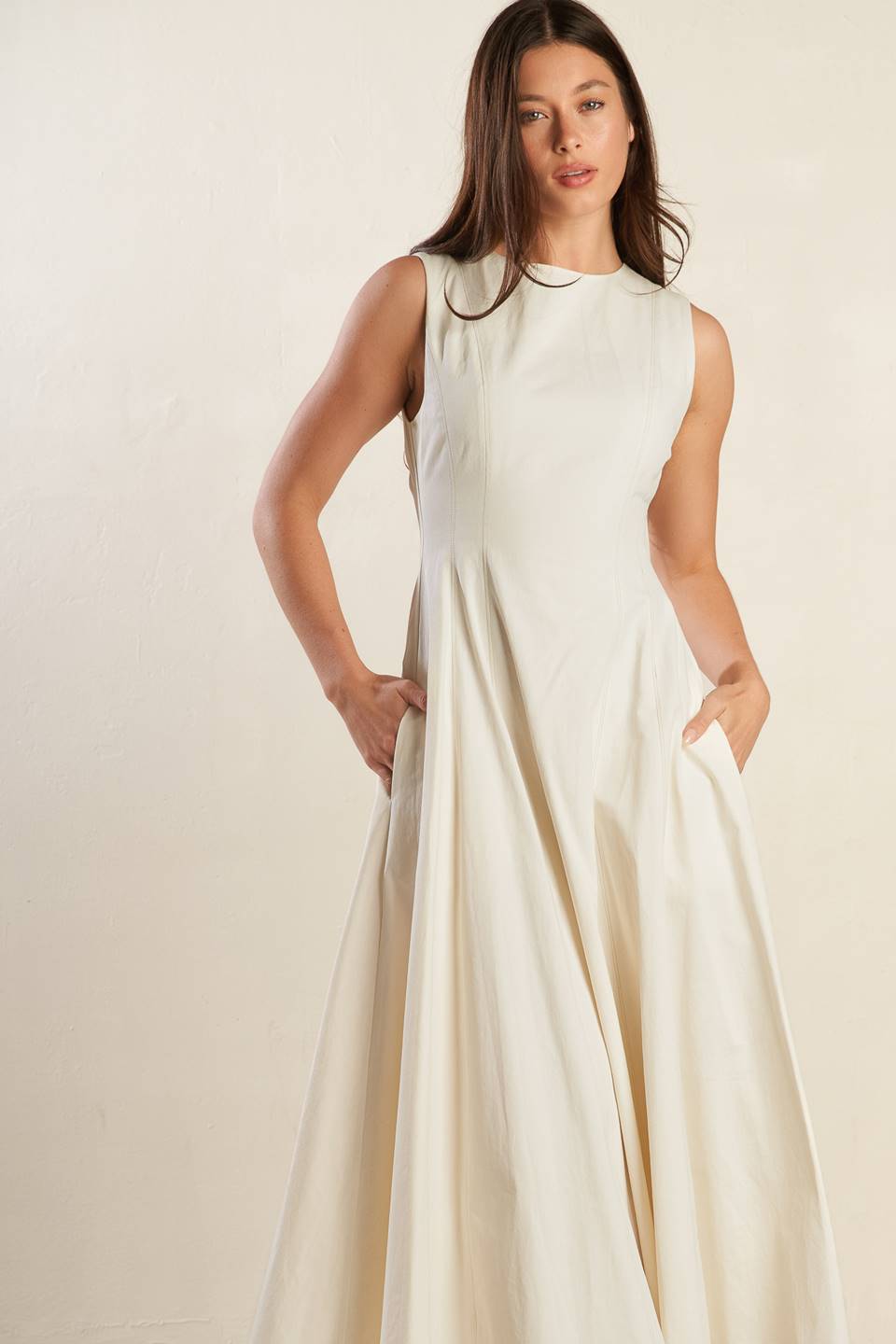 A solid woven midi dress featuring round neckline, sleeveless, full skirt and back zipper closure.