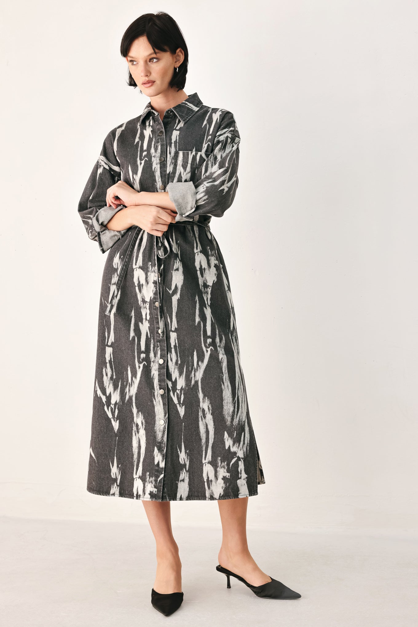 A woman modeling a long-sleeve button-front shirt denim midi dress with a gray and white abstract print | FREEMARKET