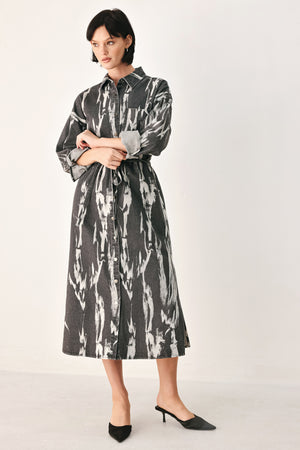 A woman modeling a long-sleeve button-front shirt denim midi dress with a gray and white abstract print | FREEMARKET