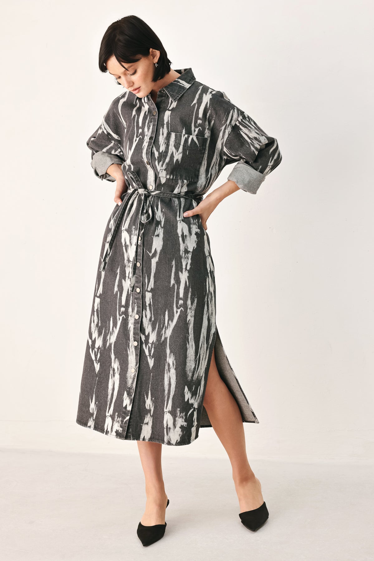 A woman modeling a long-sleeve button-front shirt denim midi dress with a gray and white abstract print | FREEMARKET