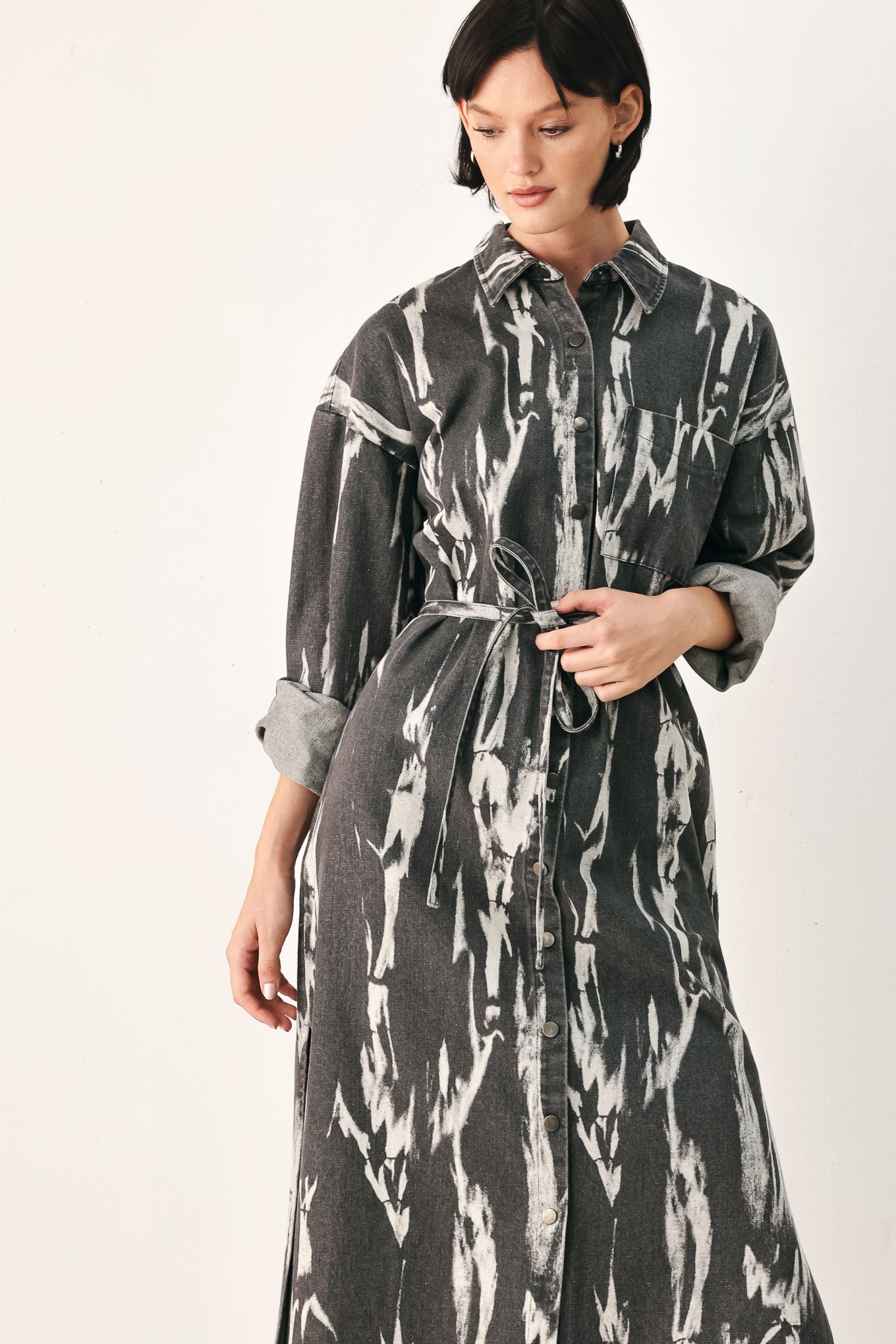 A woman modeling a long-sleeve button-front shirt denim midi dress with a gray and white abstract print | FREEMARKET
