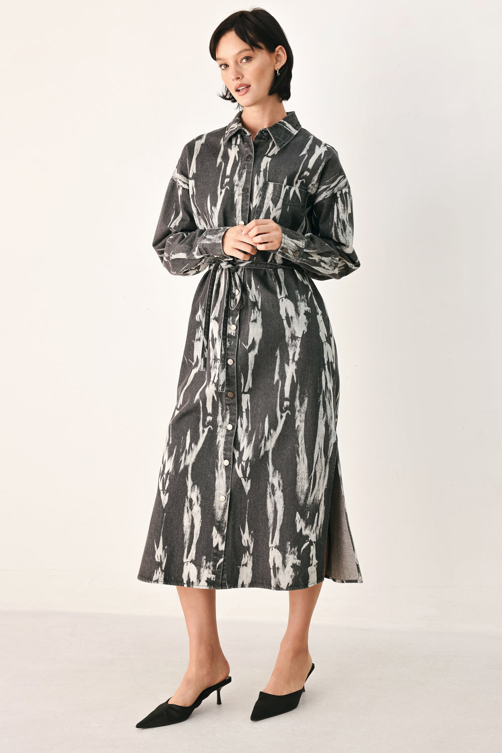 A woman modeling a long-sleeve button-front shirt denim midi dress with a gray and white abstract print | FREEMARKET