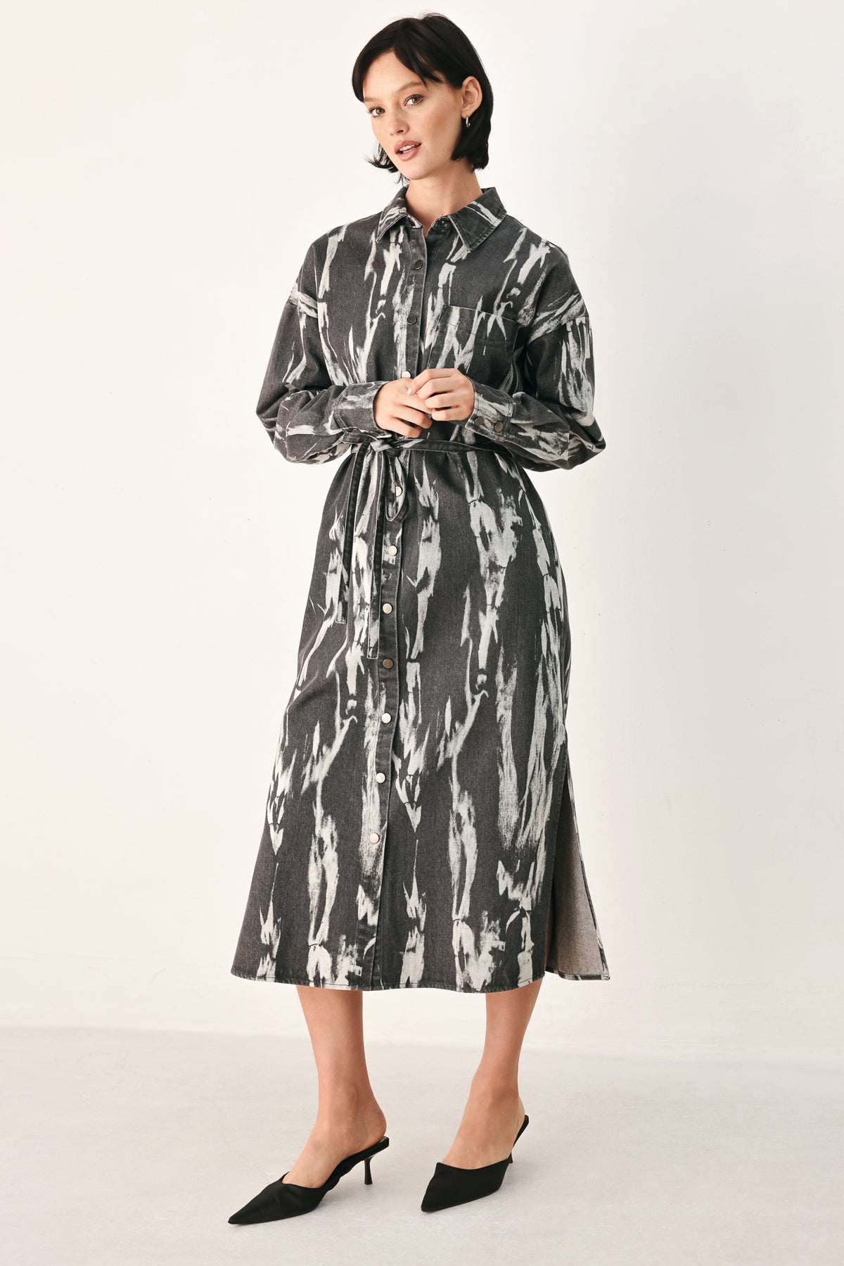 A woman modeling a long-sleeve button-front shirt denim midi dress with a gray and white abstract print | FREEMARKET