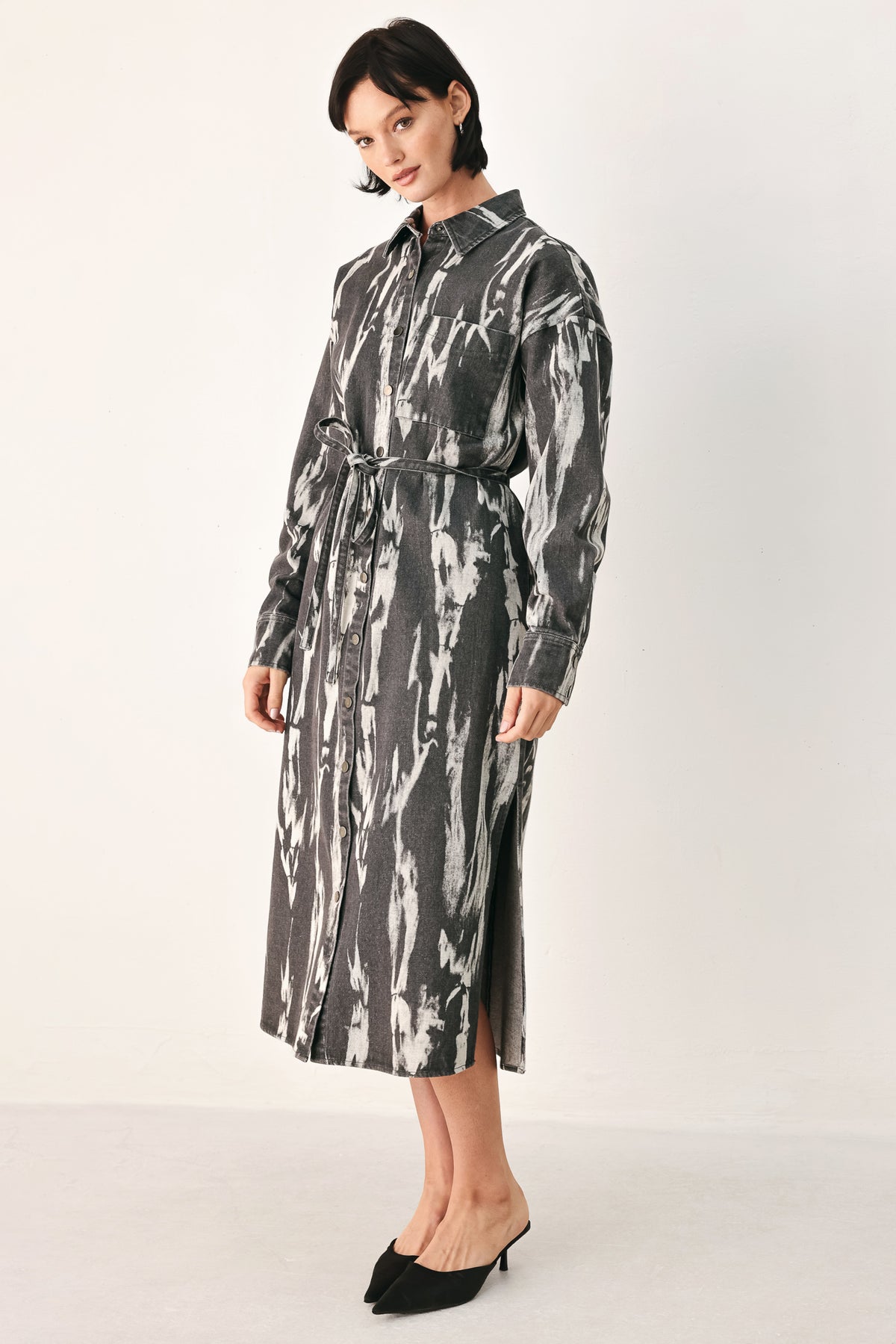 A woman modeling a long-sleeve button-front shirt denim midi dress with a gray and white abstract print | FREEMARKET