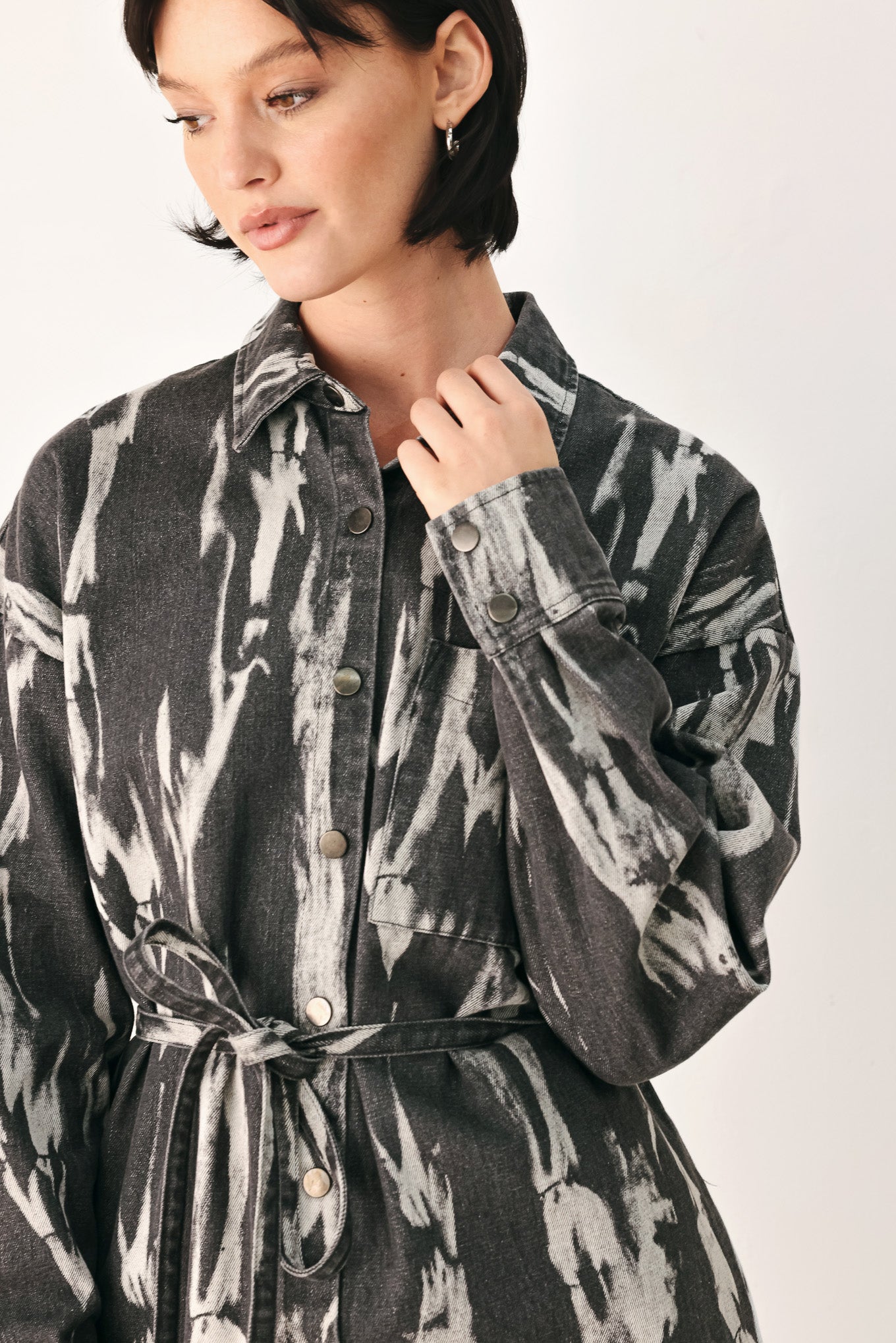 A woman modeling a long-sleeve button-front shirt denim midi dress with a gray and white abstract print | FREEMARKET