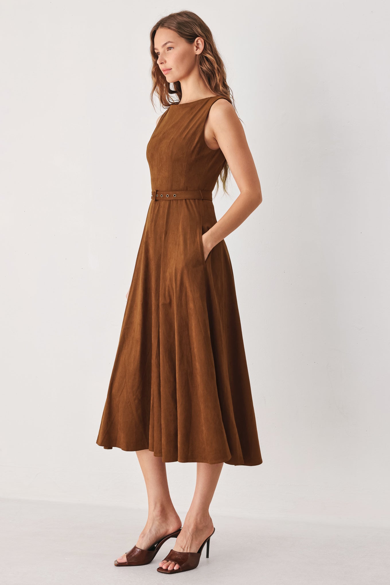 A woman wearing a sleeveless tobacco brown midi dress with a structured bodice, matching belt, and full skirt | FREEMARKET