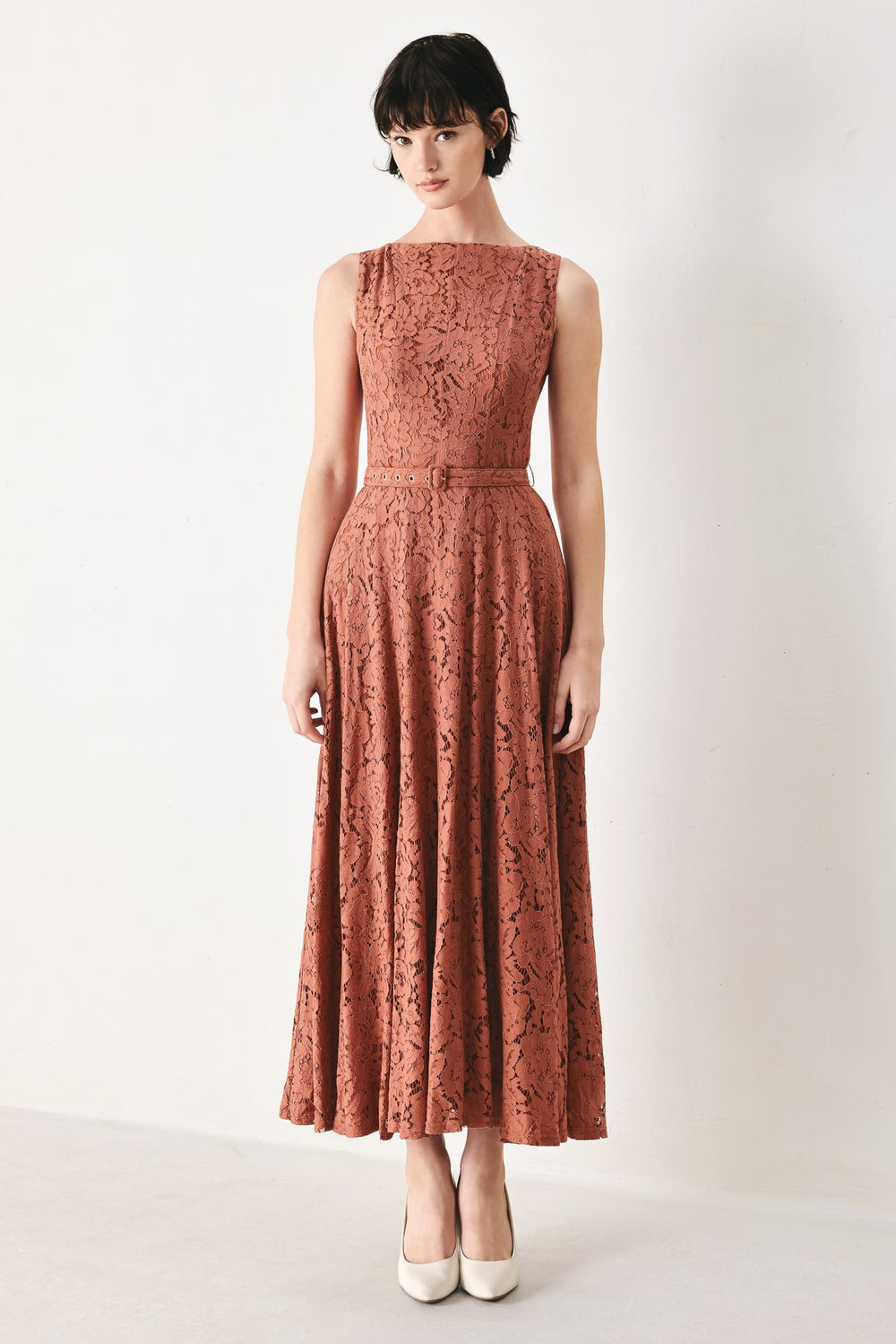 Woman wearing a rust colored lace midi dress featuring wide neckline, sleeveless, self belt, full circle skirt and back zipper closure | FREEMARKET